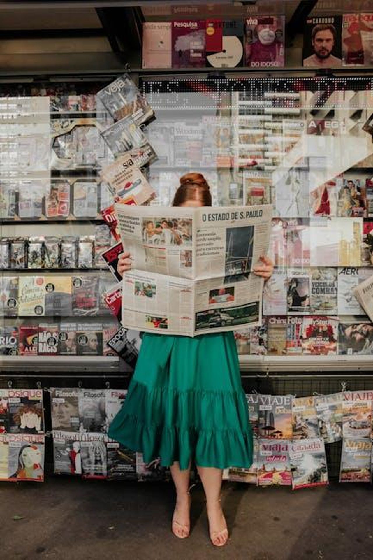 Aggiornamenti_sulla_Salute_di_Bruce_Willis_Durante_la_Diagnosi_di_Demenza_Frontotemporale_imgARgrvlv - Confidenze24 Source: Gabi Santana - pexels - Woman in green dress reading newspaper at street magazine stand outdoors.