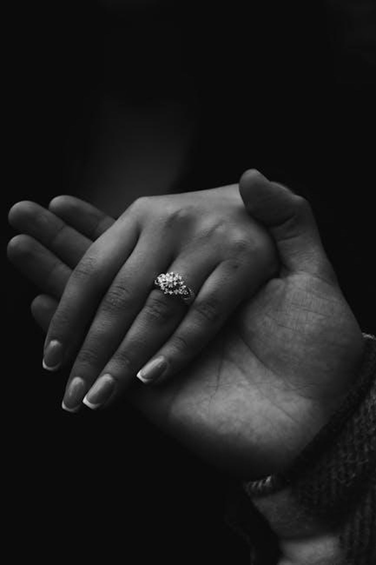 Alesha_sposa_segretamente_Azuka_Ononye_eteUCGfr1Z - Confidenze24 Source: Elvir Novruzov - pexels - Intimate black and white close-up of hands, featuring a romantic gesture with a diamond ring.