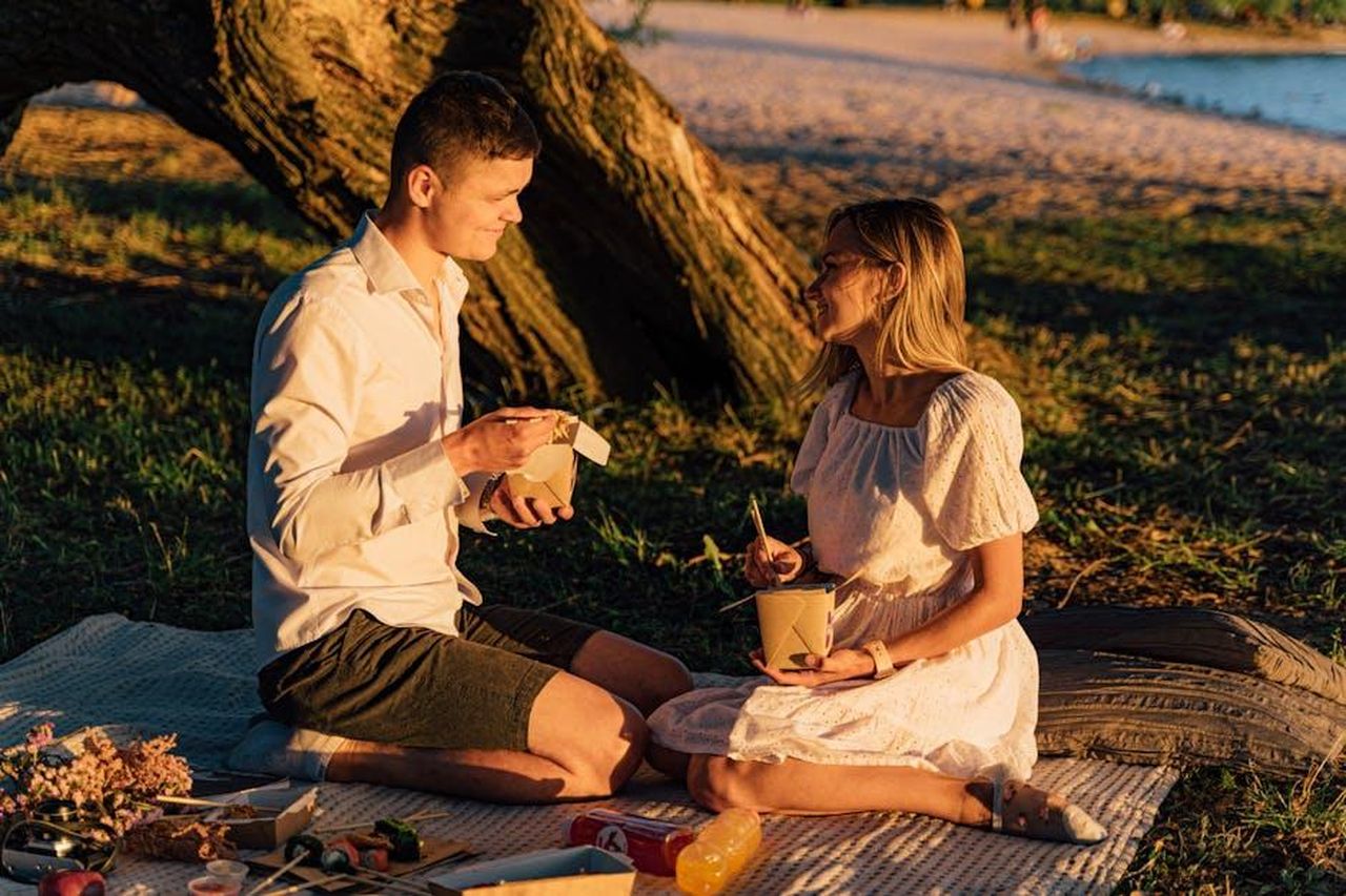 An_Amazing_Couple_BubOmf7u6j - Confidenze24 Source: Antoni Shkraba - pexels - Couple enjoys a sunset picnic with takeout noodles by the beach. Perfect summer evening.