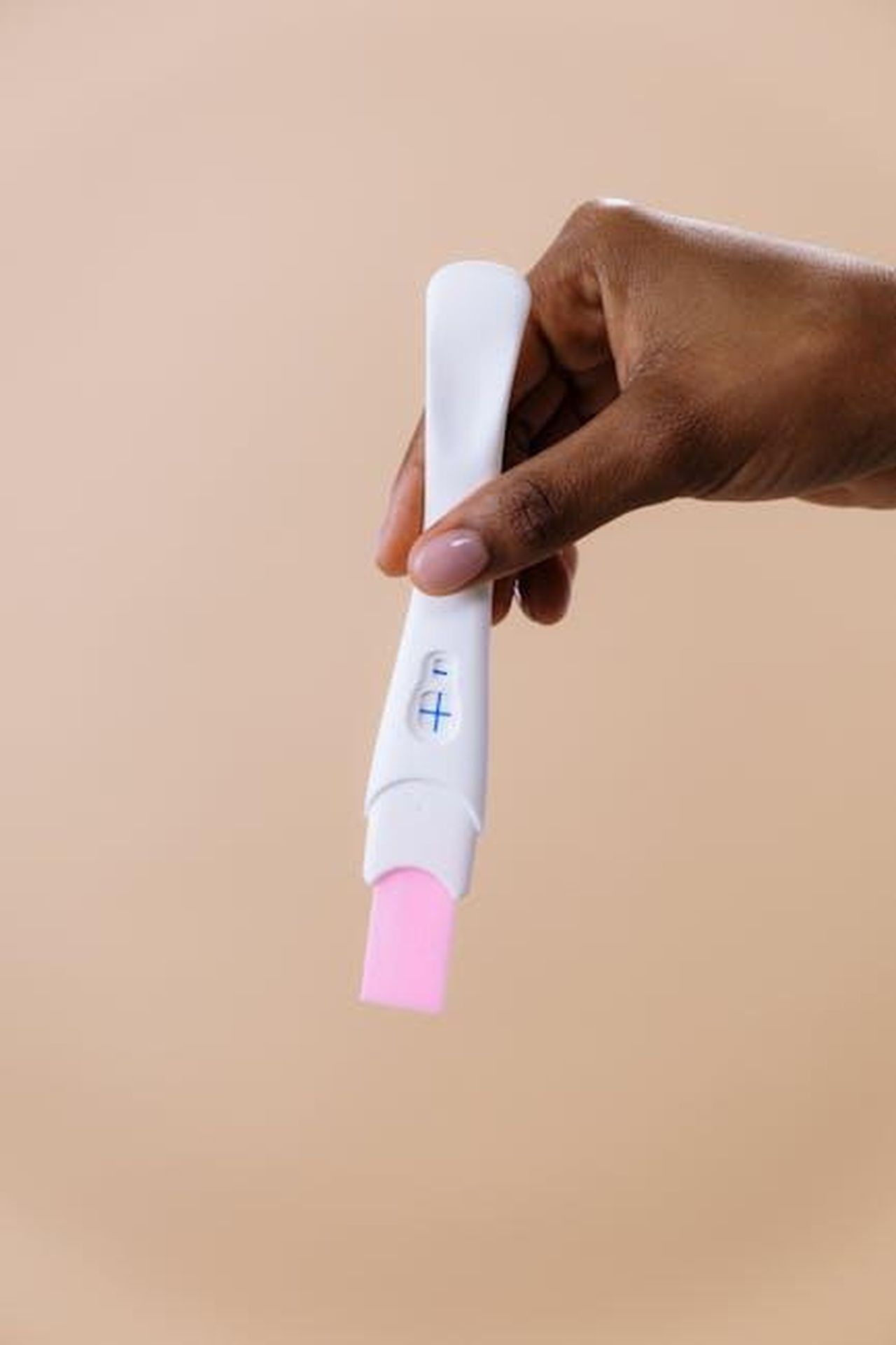 Annuncio_della_gravidanza_di_Michelle_Keegan_gZanVs8hOh - Confidenze24 Source: cottonbro studio - pexels - A close-up image of a hand holding a positive pregnancy test with a beige background.
