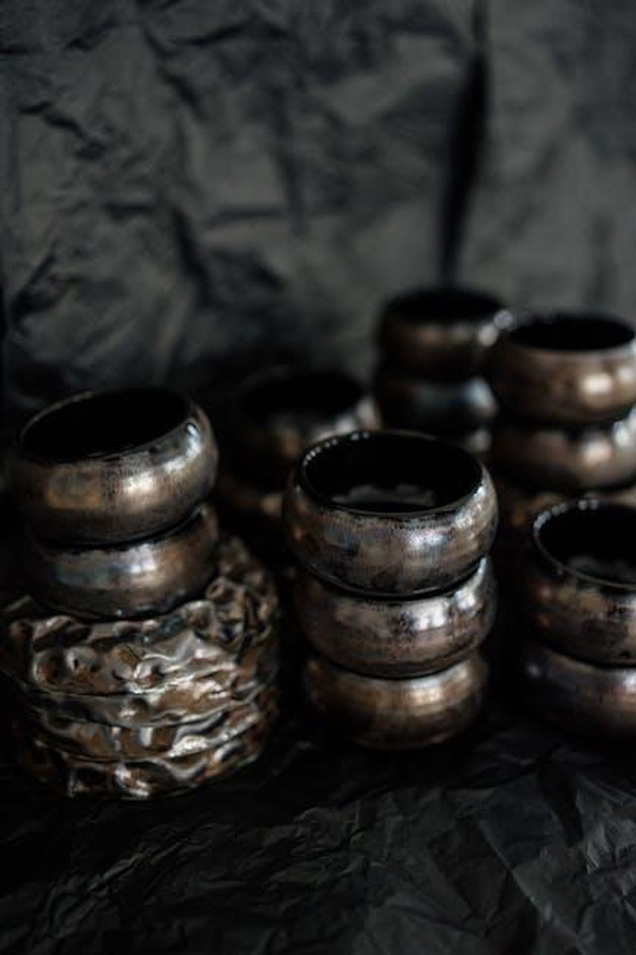 Articoli_della_nuova_collezione_y0XF8VuRkY - Confidenze24 Source: Галина Ласаева - pexels - Artistic display of handmade pottery with rustic textures and a dark background, showcasing traditional craftsmanship.