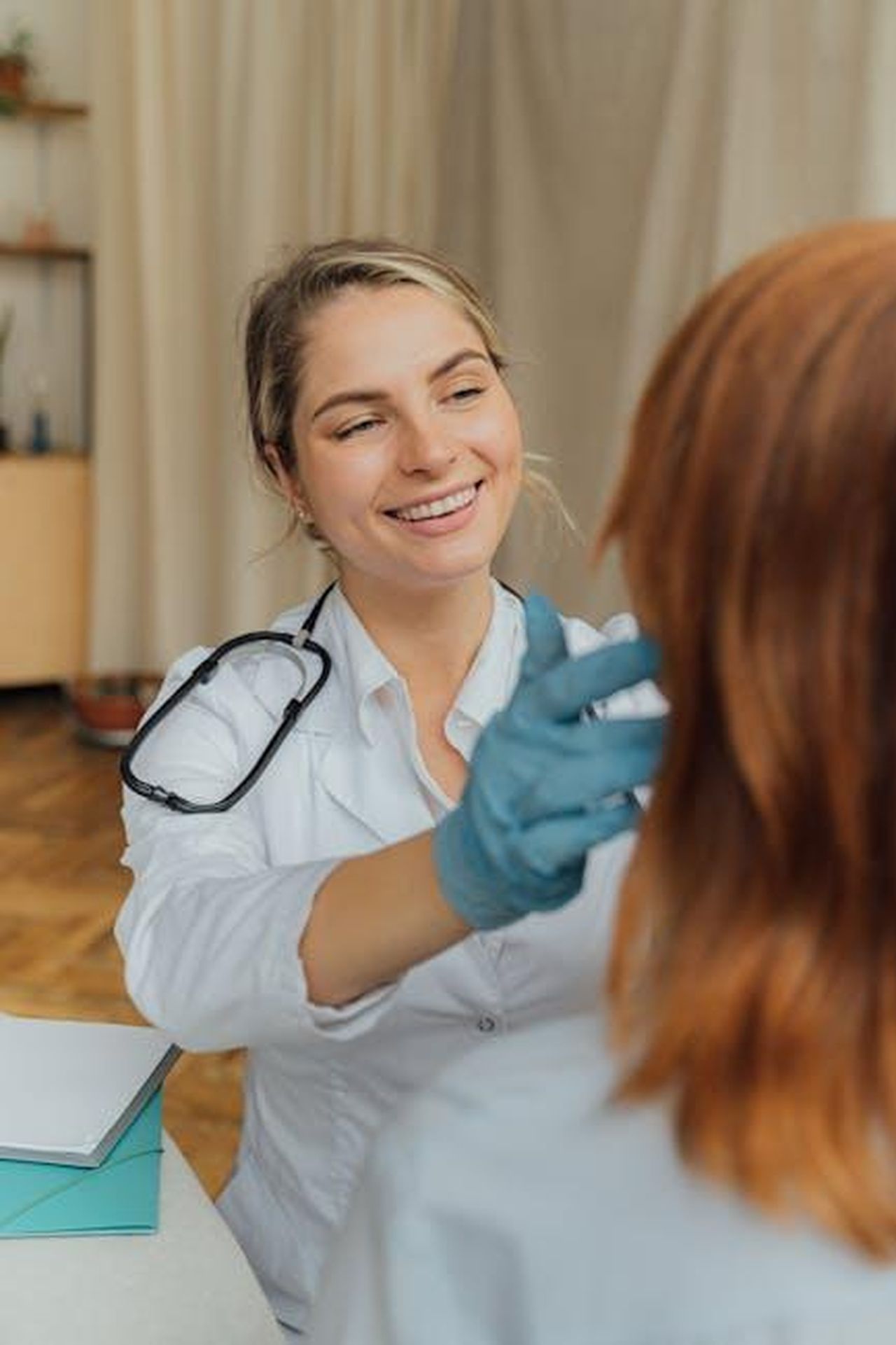 Assicurati_di_aver_ricevuto_entrambe_le_dosi_di_MMR_ztXJzVlZ4e - Confidenze24 Source: Antoni Shkraba - pexels - A cheerful healthcare professional examining a patient indoors, promoting positive healthcare experiences.
