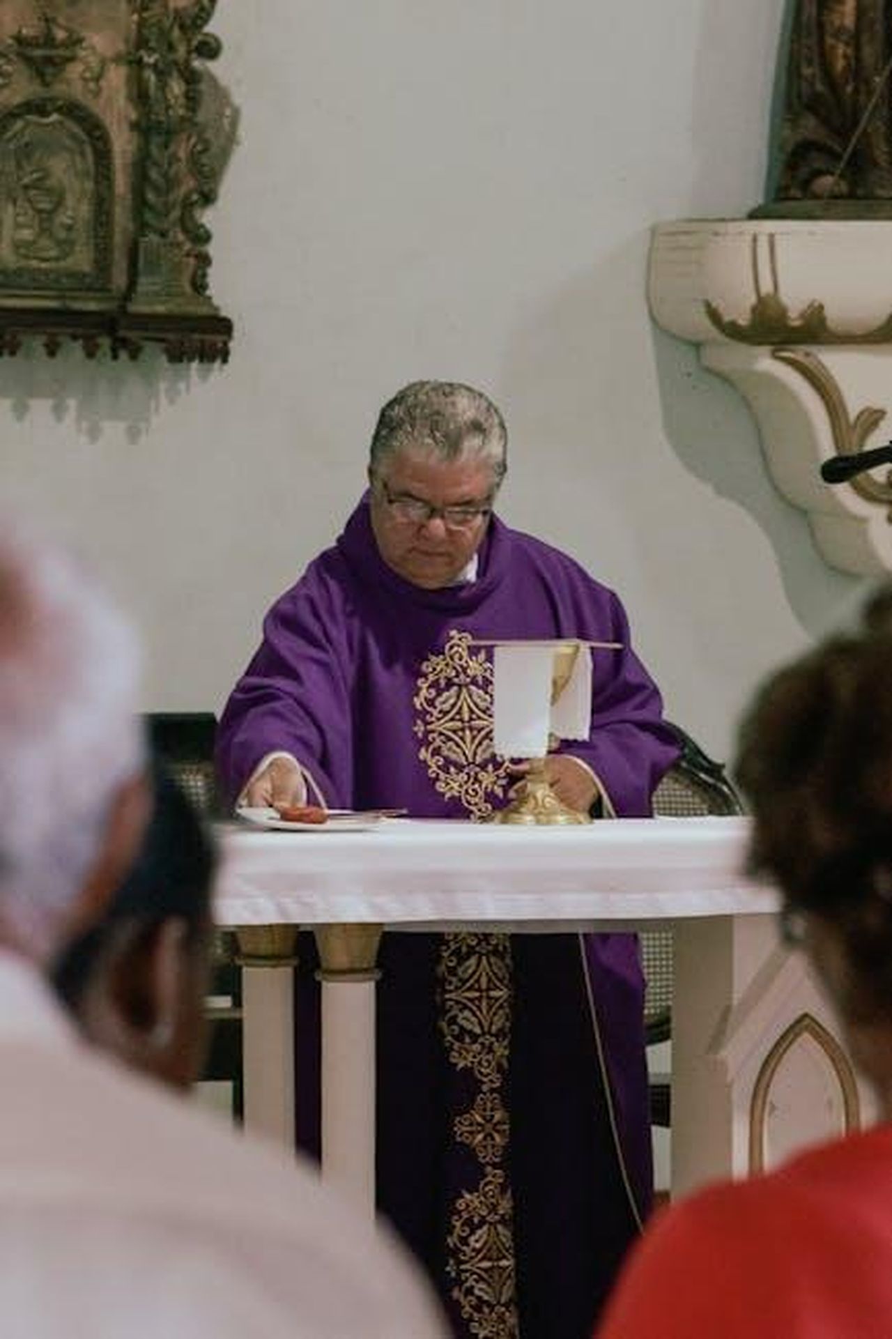 Atti_di_servizio_WssMc7YU5F - Confidenze24 Source: Mehmet Turgut Kirkgoz - pexels - A Catholic priest in a purple vestment conducting a Eucharist ceremony inside a church.