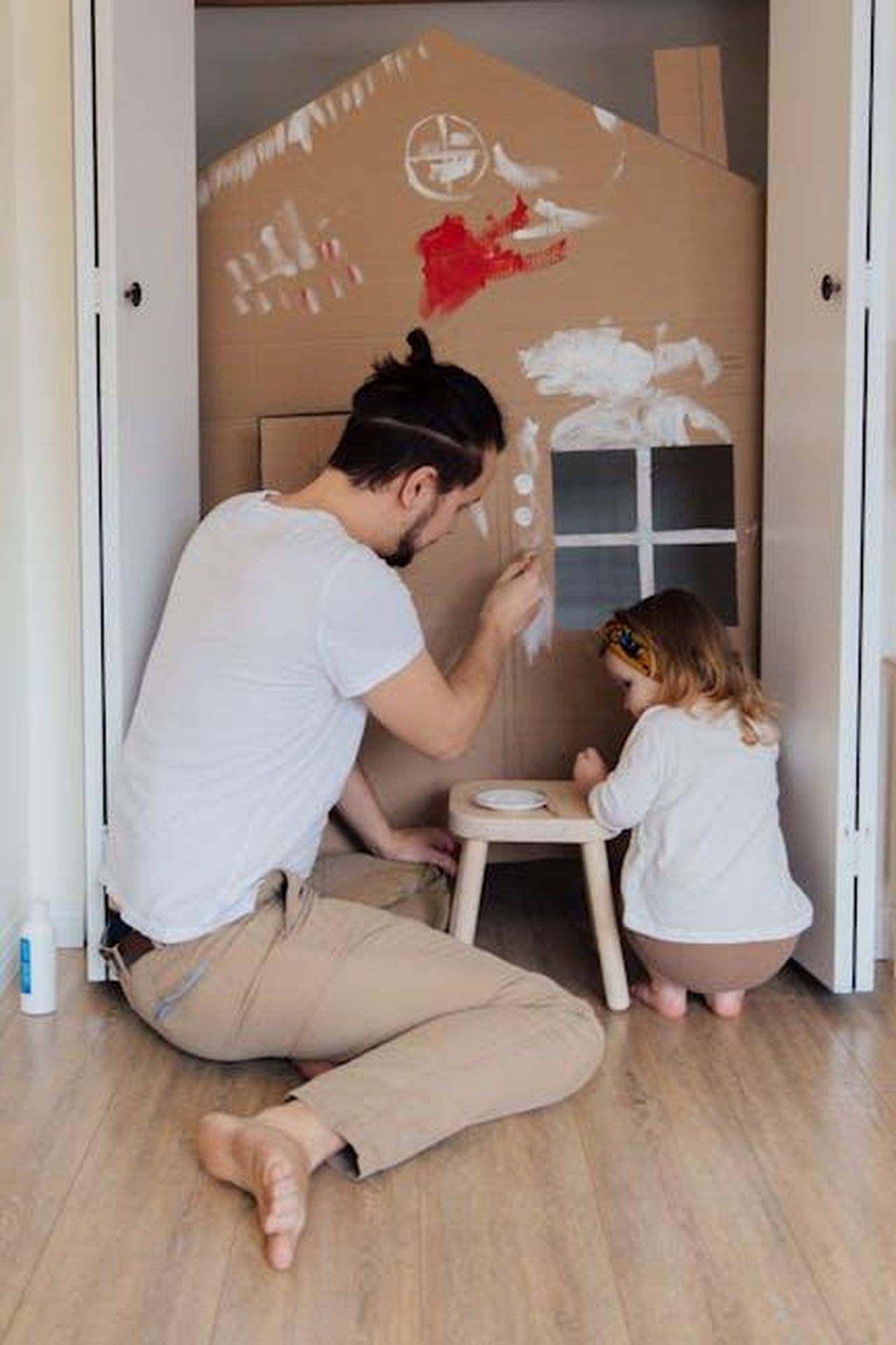 Attivit_quotidiane_di_Kate_Middleton_9pD0wffh9u - Confidenze24 Source: Tatiana Syrikova - pexels - Father and daughter painting a cardboard house indoors, enjoying quality time together.