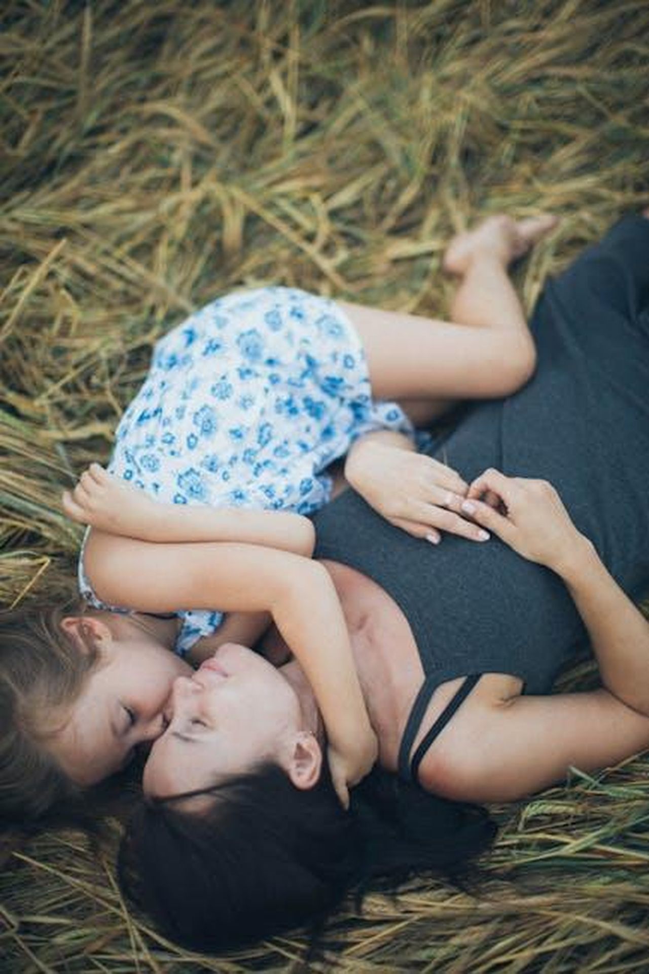 Avere_una_figlia_vfxWKHajKH - Confidenze24 Source: Elina Sazonova - pexels - A mother and daughter share a tender moment lying together on a grassy field.