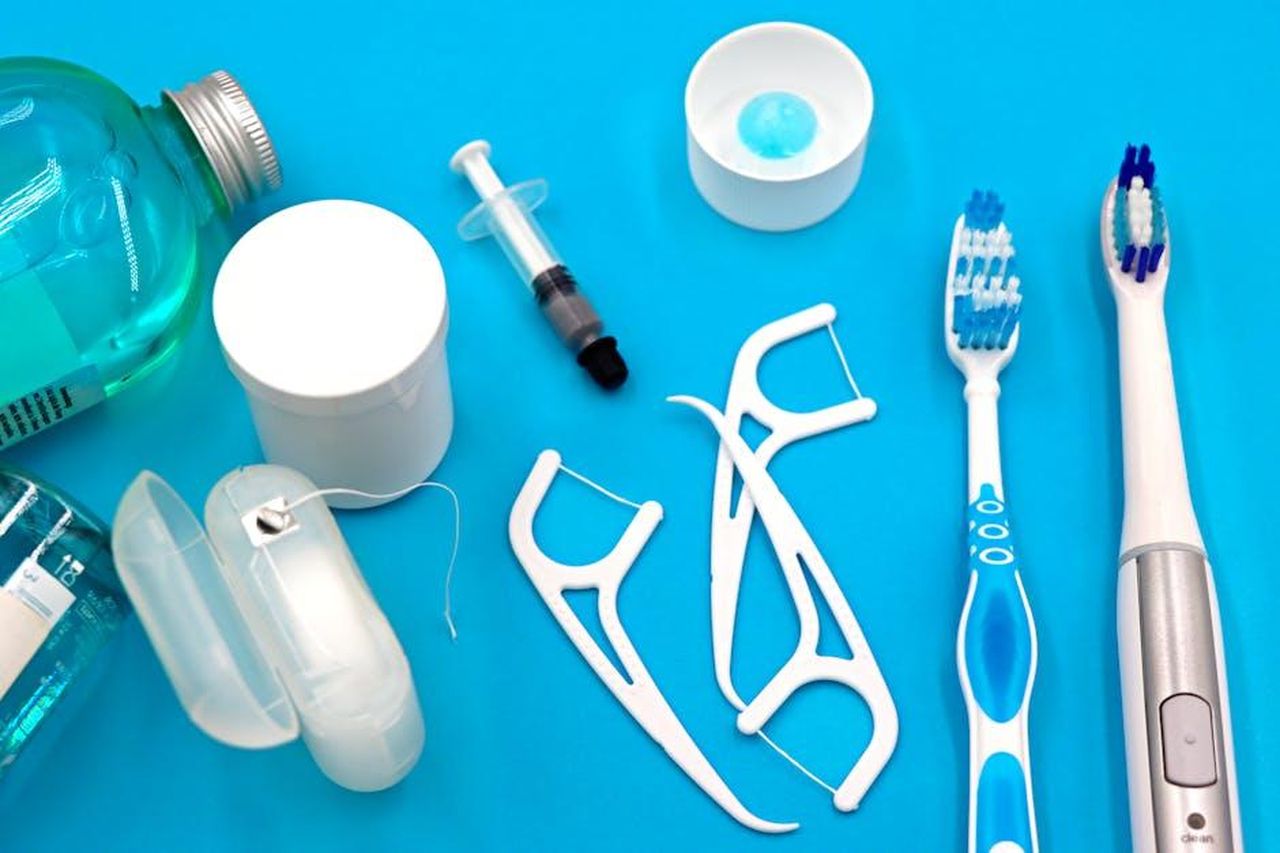 Beveva_anche_il_collutorio_tWsM50ZNdT - Confidenze24 Source: Marta Branco - pexels - A variety of dental hygiene tools arranged neatly on a vibrant blue surface, showcasing oral care essentials.