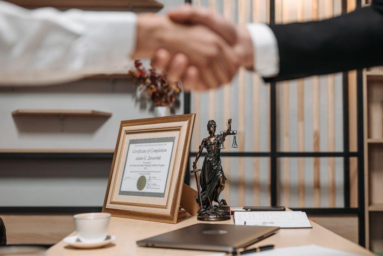 Bilancia_23_SETTEMBRE__22_OTTOBRE_4FbIU6vAvC - Confidenze24 Source: Pavel Danilyuk - pexels - A professional handshake in an office with diploma and Lady Justice statue, symbolizing law and achievement.