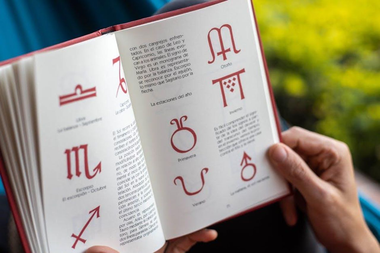 Bilancia_23_settembre__22_ottobre_TrGtxMjt4Q - Confidenze24 Source: Paoko - pexels - Open book displaying zodiac symbols and seasonal descriptions being held by hands.