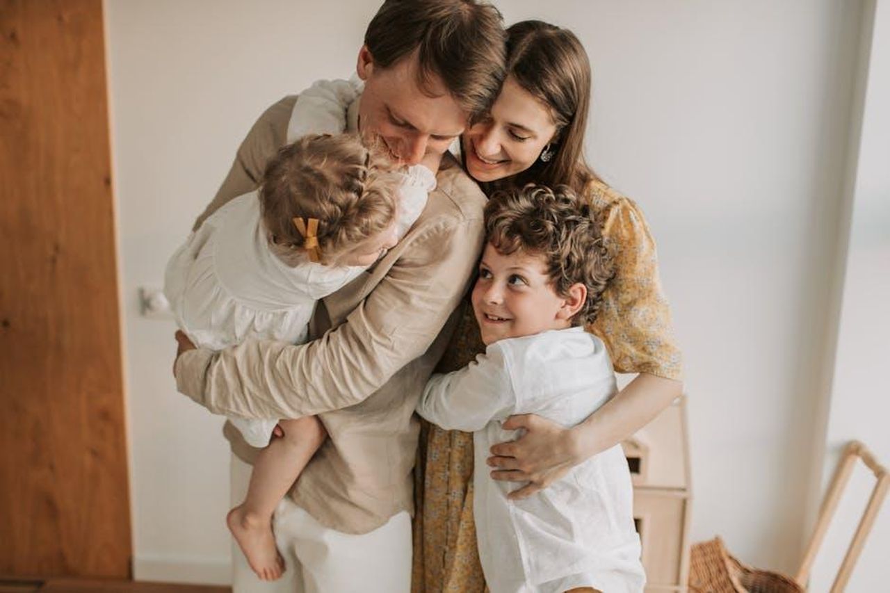 Bindi_Irwin_parla_dellimportanza_del_tempo_in_famiglia_c9fgyyBXaF - Confidenze24 Source: Vlada Karpovich - pexels - A heartwarming scene of a family hugging indoors, showcasing love and togetherness.
