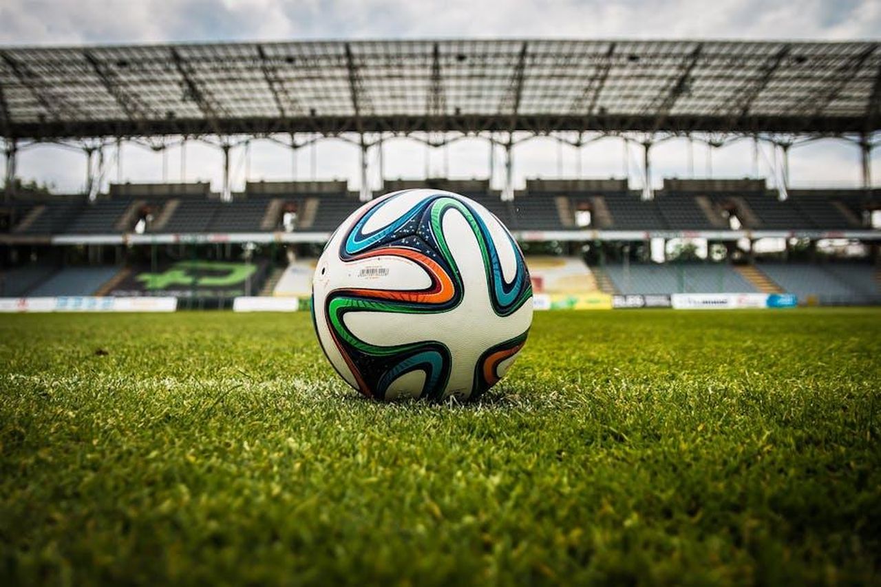 Brady_e_il_suo_amore_per_il_football_czAWcd14w7 - Confidenze24 Source: Pixabay - pexels - A vibrant soccer ball rests on a lush green field inside an empty stadium, capturing the essence of sports.
