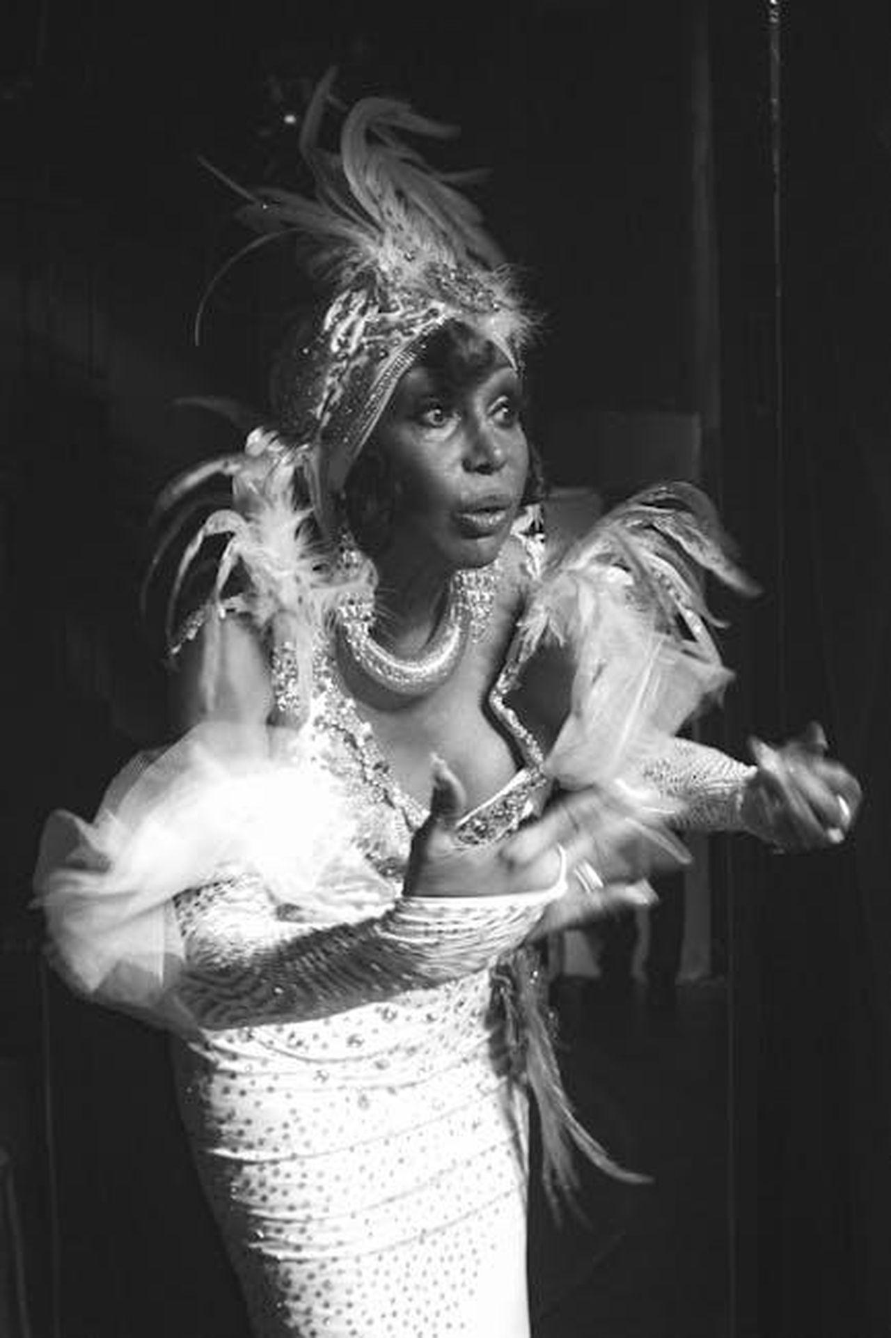Brian_Austin_Green_risponde_alle_provocazioni_W1WvCoIw2b - Confidenze24 Source: Bruno Curly - pexels - Black and white image of a performer in an elaborate feathered costume preparing backstage.