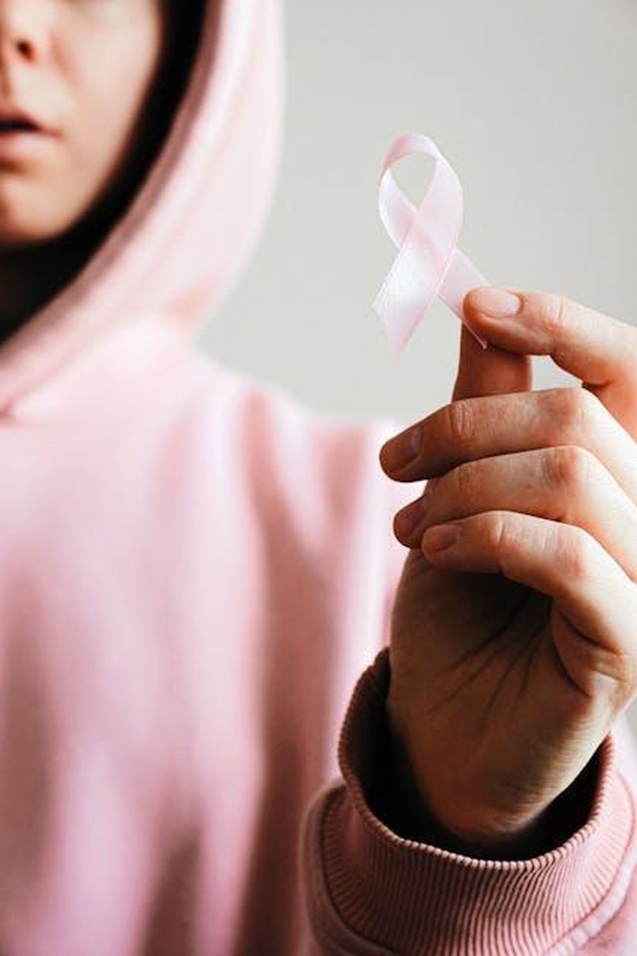 Cancro_22_GIUGNO__22_LUGLIO_3W0nDui6jm - Confidenze24 Source: Anna Shvets - pexels - Close-up of a person holding a pink ribbon symbolizing breast cancer awareness.