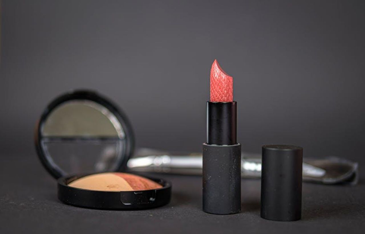 Caratteristiche_del_rossetto_Mon_Caramel_ocPBV50OEV - Confidenze24 Source: Dmitri Koshelev - pexels - Black lipstick and blush with compact on dark background, showcasing elegant makeup essentials.