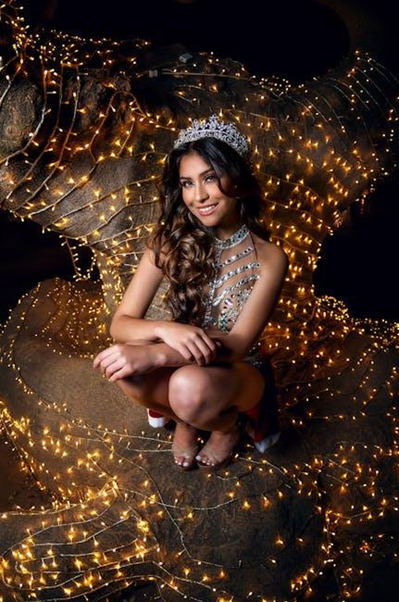 Caratteristiche_delle_luci_ricaricabili_Gw8CTywaOQ - Confidenze24 Source: Manuel Cortés - pexels - Glamorous woman in tiara poses surrounded by twinkling lights at night.