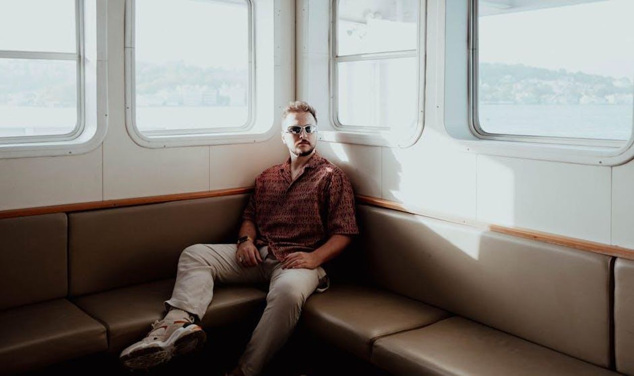 Caratteristiche_delle_scarpe_da_barca_2gvPQgE4pP - Confidenze24 Source: Furkan Elveren - pexels - A fashionable man in sunglasses sits on a ferry in Istanbul under the afternoon sun.