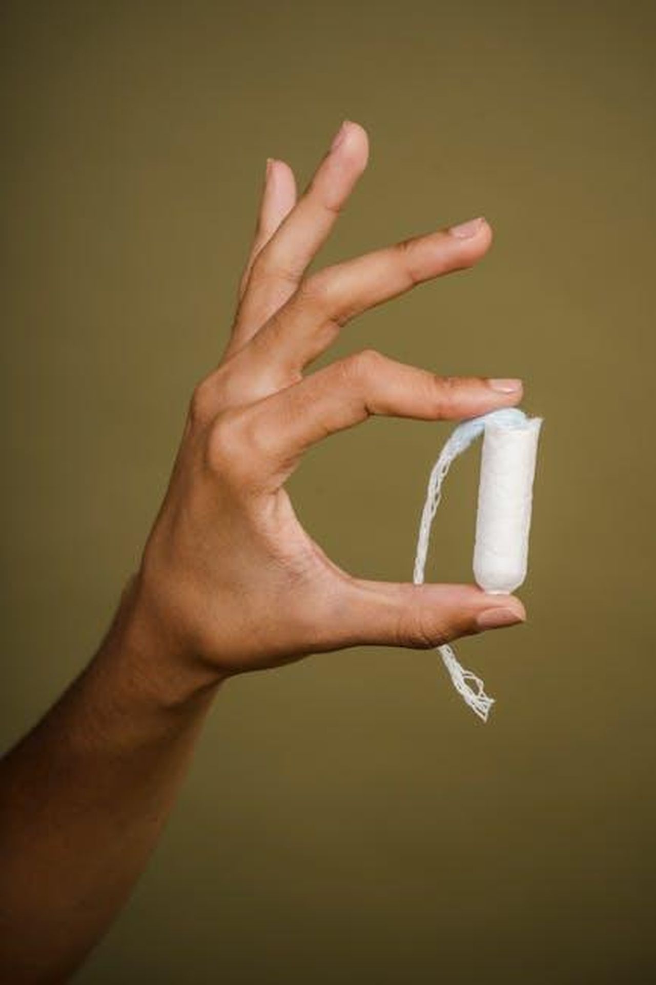 Cat_criticata_dagli_spettatori_di_This_Morning_FwWFDra0kD - Confidenze24 Source: Sora Shimazaki - pexels - A hand gracefully holds a white tampon against an olive background, representing feminine hygiene.