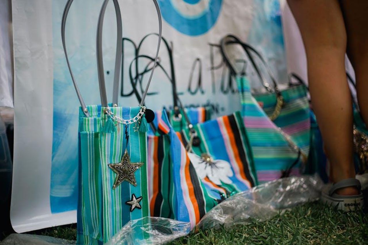 Charm_per_borse_Disney_un_must_per_i_fan_QrXqpFKvx1 - Confidenze24 Source: Elias Jara - pexels - Vibrant striped bags with star charms displayed at an outdoor market.