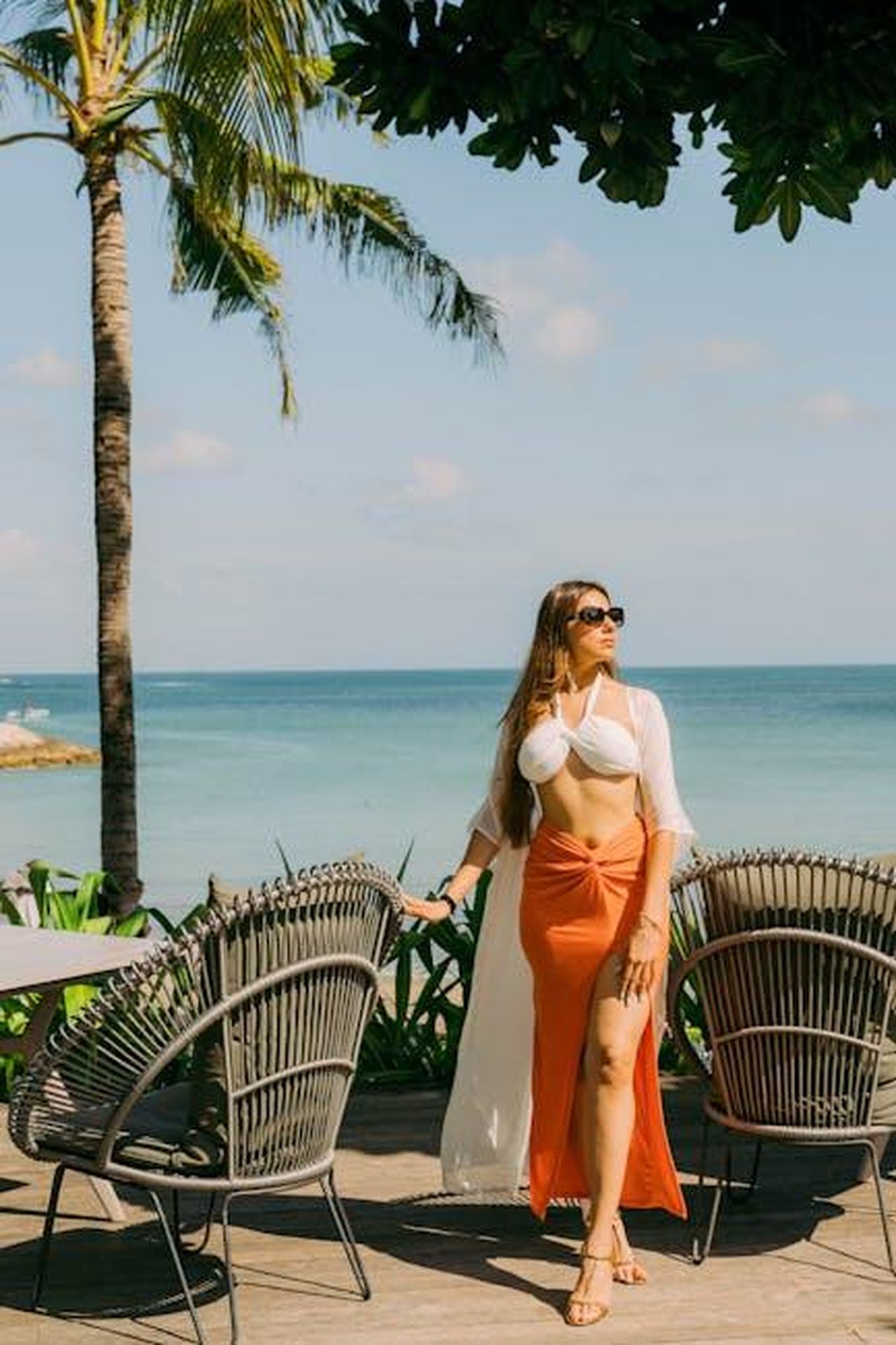 Chi_Torner_per_la_Stagione_2_di_Paradise_Q1uHvghBPY - Confidenze24 Source: kriisszzz kriisszzz - pexels - Elegant model posing by the ocean under palm trees in Bali, embracing tropical vibes.