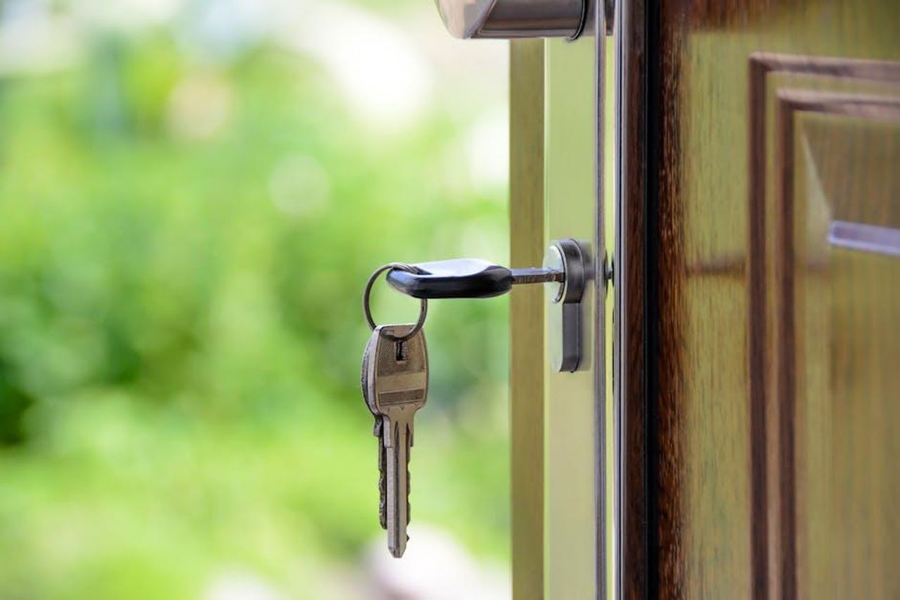 Chi__Claire_Collier_KDSXZ0lqIq - Confidenze24 Source: AS Photography - pexels - Key inserted in door lock against a blurred green background, symbolizing security and real estate.
