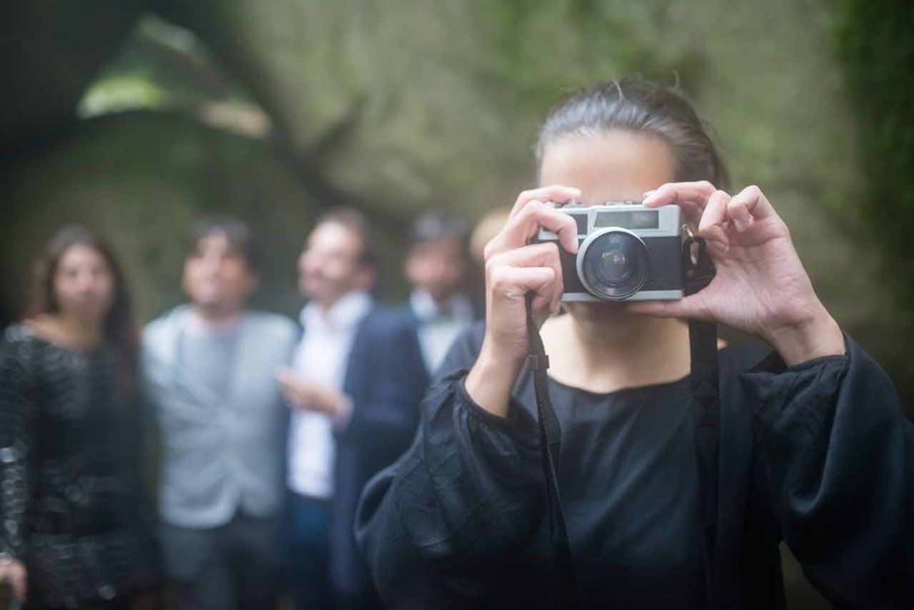 Chi_saranno_gli_ospiti_del_matrimonio_7GiZgBx07r - Confidenze24 Source: Kampus Production - pexels - Woman taking photo of guests in outdoor setting, capturing memorable moments.