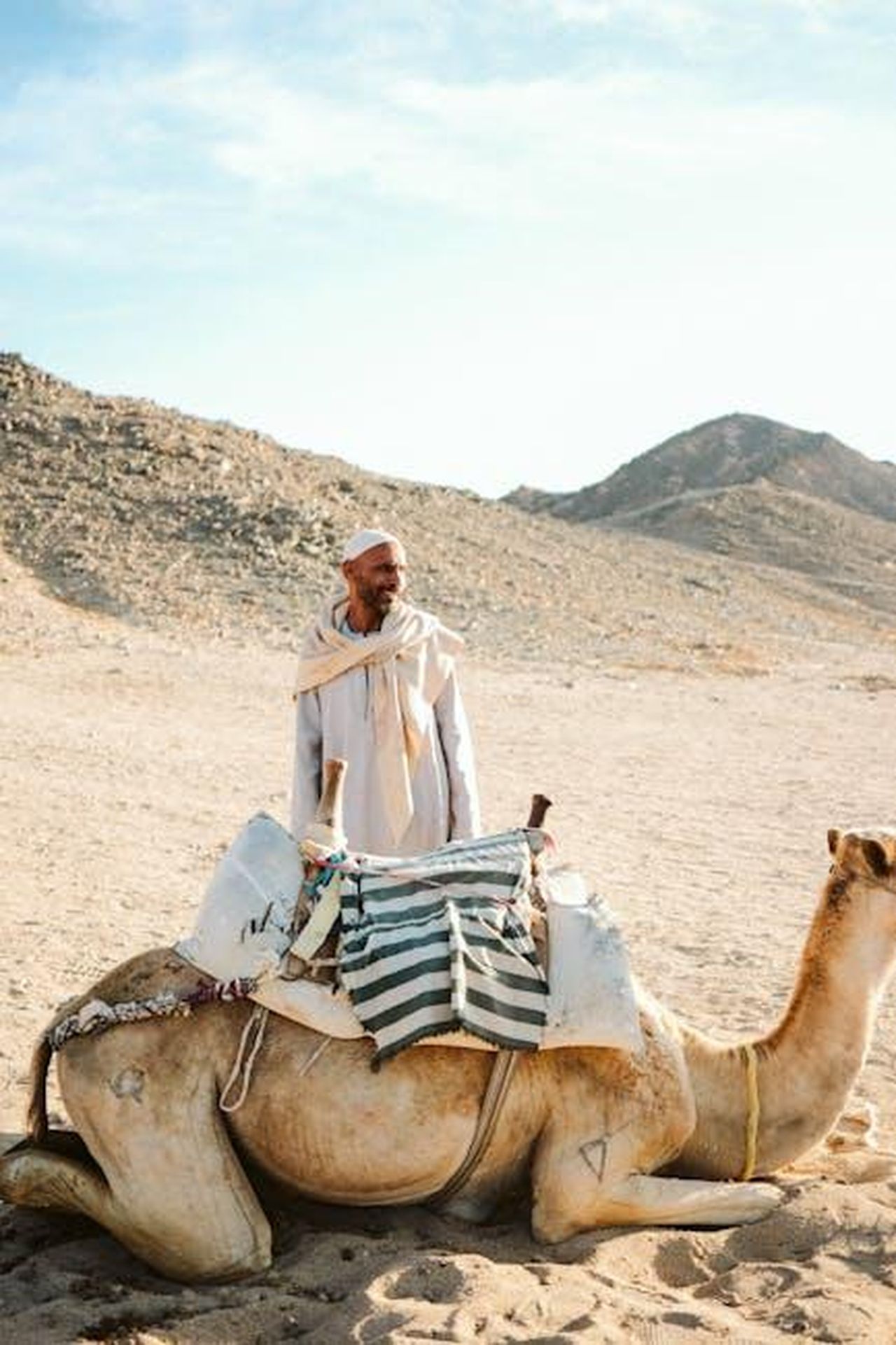 Ci_manca_un_grande_vuoto_senza_la_sua_presenza_PFOEFE2KFG - Confidenze24 Source: Emre Akyol - pexels - A Bedouin man sits on a camel in a barren desert landscape under a bright sky.