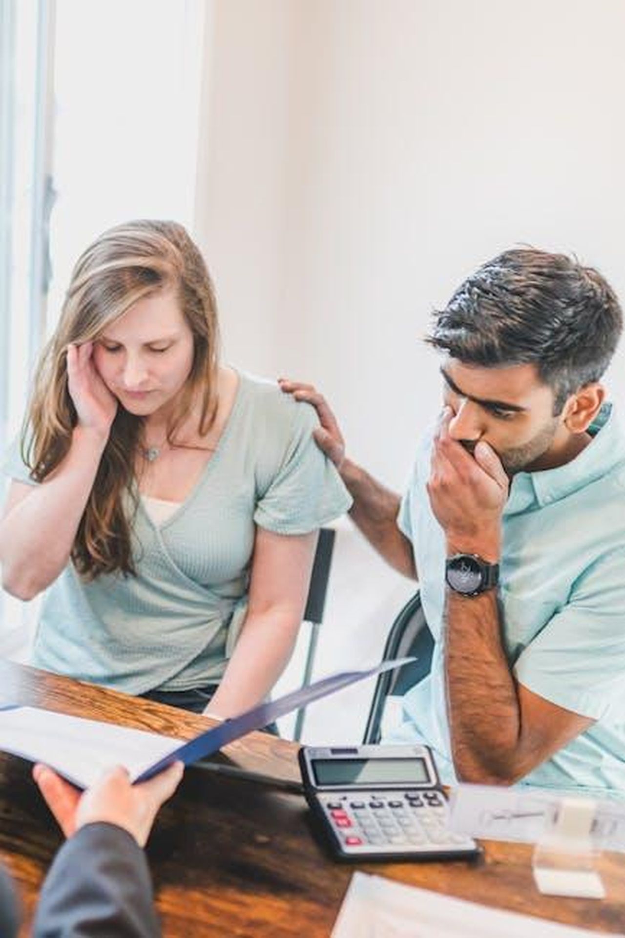 Ci_sono_alcuni_segnali_di_allerta_w9v1tg0ZgA - Confidenze24 Source: RDNE Stock project - pexels - A young couple sits with a real estate agent, reviewing documents and looking concerned about buying a new home.