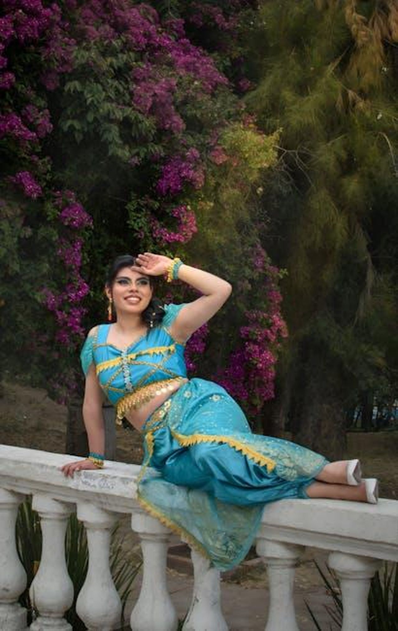 Collane_e_bracciali_Disney_eleganza_e_stile_ecDdKpPQbe - Confidenze24 Source: Angel Rkaoz - pexels - Woman in bright traditional outfit posing outdoors with vibrant flowers.