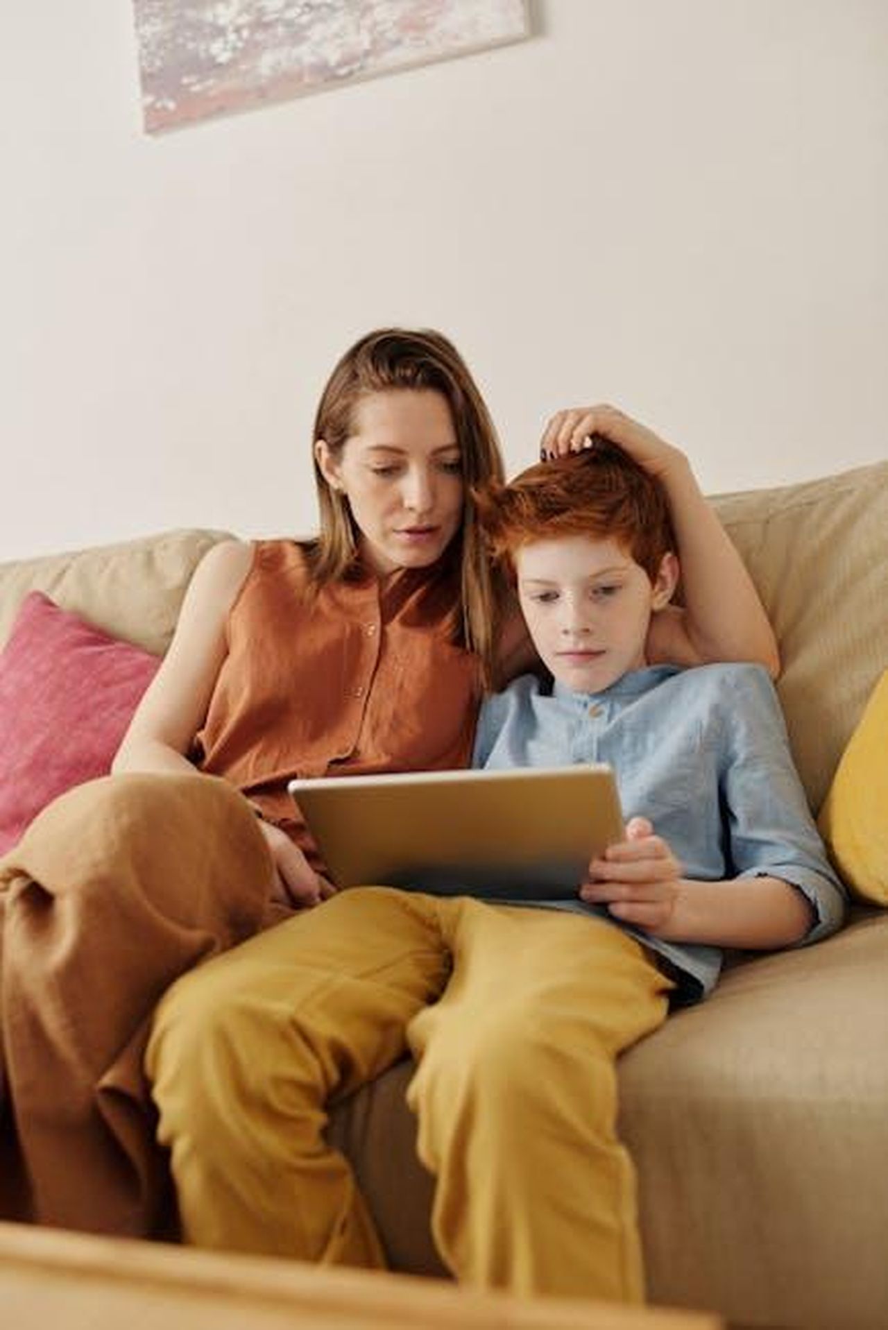 Come_affrontare_il_fenomeno_con_i_propri_figli_EdRIg1hYGC - Confidenze24 Source: Julia M Cameron - pexels - A mother and her son sitting on a couch, using a tablet for education and bonding time.