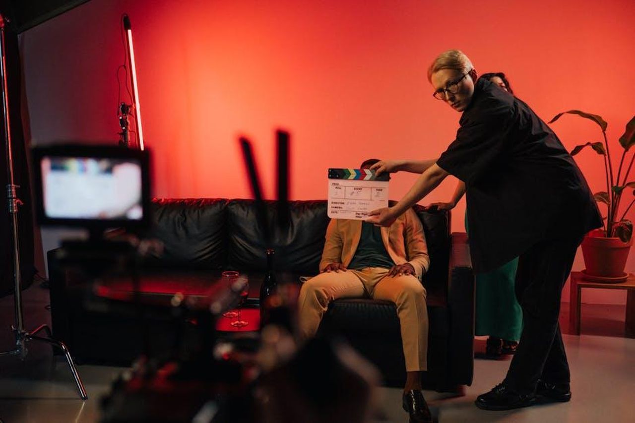 Come_guadagna_Sterling_K_Brown_vi4PsNWfaS - Confidenze24 Source: Ron Lach - pexels - Film production team setting up a scene on an indoor set with dramatic lighting.