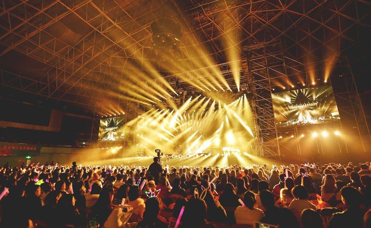 Come_hanno_reagito_i_fan_ApPN4wpFRm - Confidenze24 Source: Teddy Yang - pexels - Dynamic concert scene with vibrant crowd and dazzling stage lights indoors.