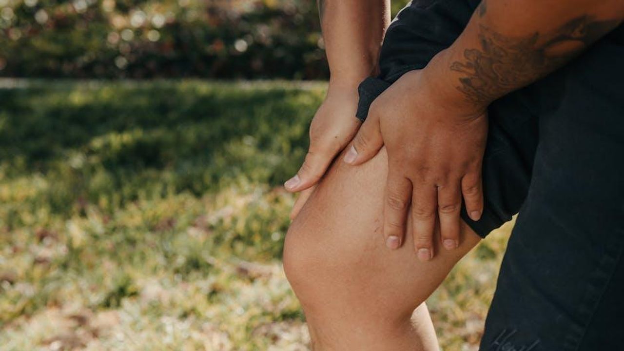 Come_hanno_reagito_i_follower_M8znDXZhxQ - Confidenze24 Source: Kindel Media - pexels - A close-up image of a person holding their knee, indicating pain or injury, with greenery in the background.