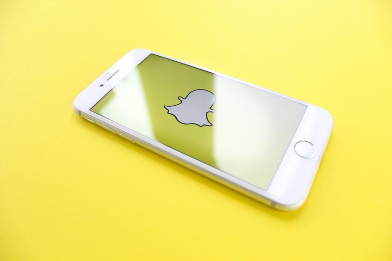 Come_hanno_reagito_i_follower_v6zz0LTb58 - Confidenze24 Source: Thought Catalog - pexels - White smartphone displaying Snapchat logo on a bright yellow background, angled view.