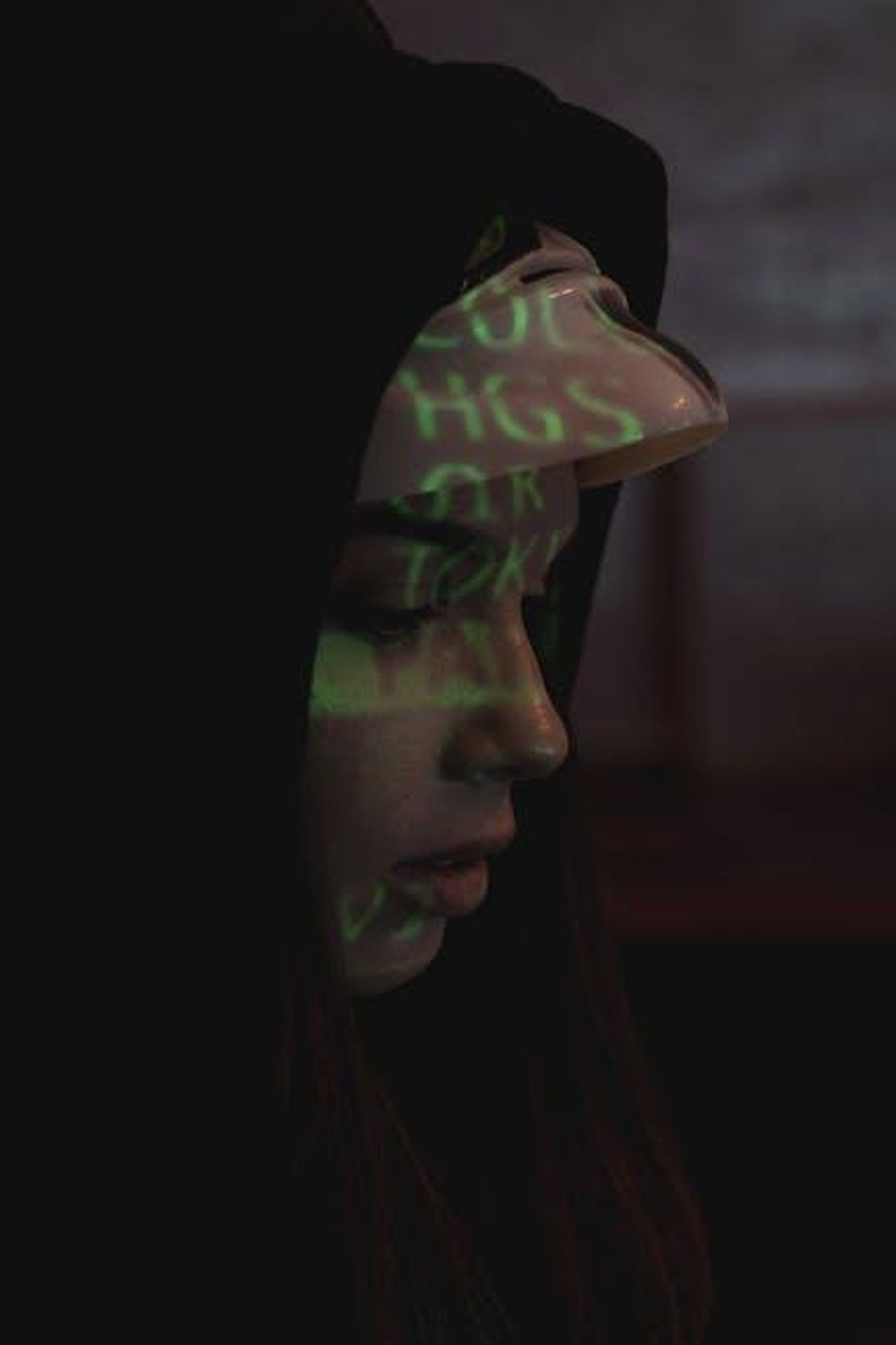 Come_possiamo_comprendere_le_conseguenze_di_queste_azioni_iXHYoCTvUR - Confidenze24 Source: Tima Miroshnichenko - pexels - A woman in a dark hoodie with digital code projected on her face symbolizes cyber security themes.