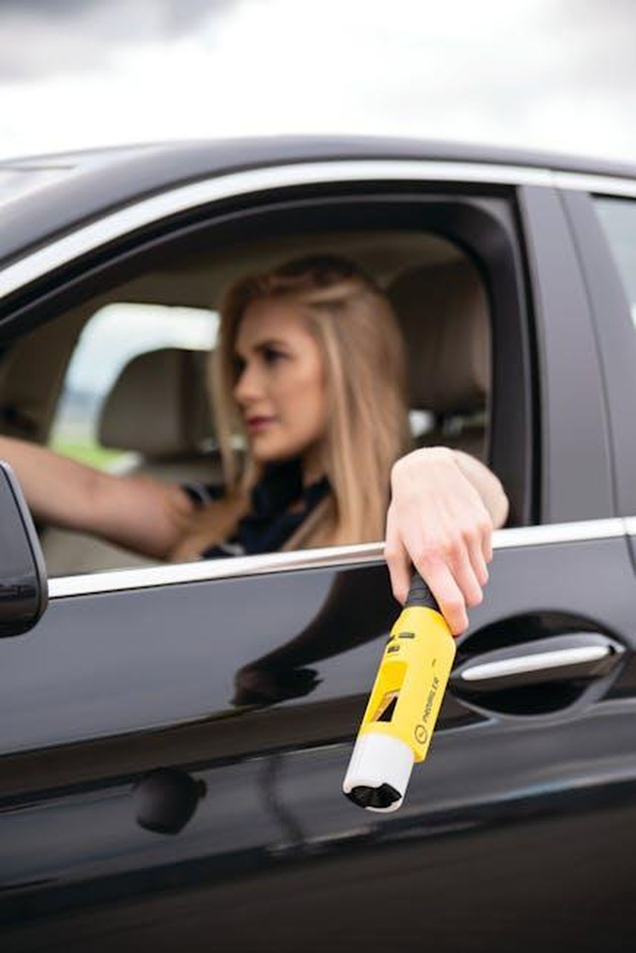 Come_posso_prevenire_la_tubercolosi_wGUrsgOzG0 - Confidenze24 Source: Łukasz Promiler - pexels - Close-up of woman extending breathalyzer from car window, emphasizing road safety.