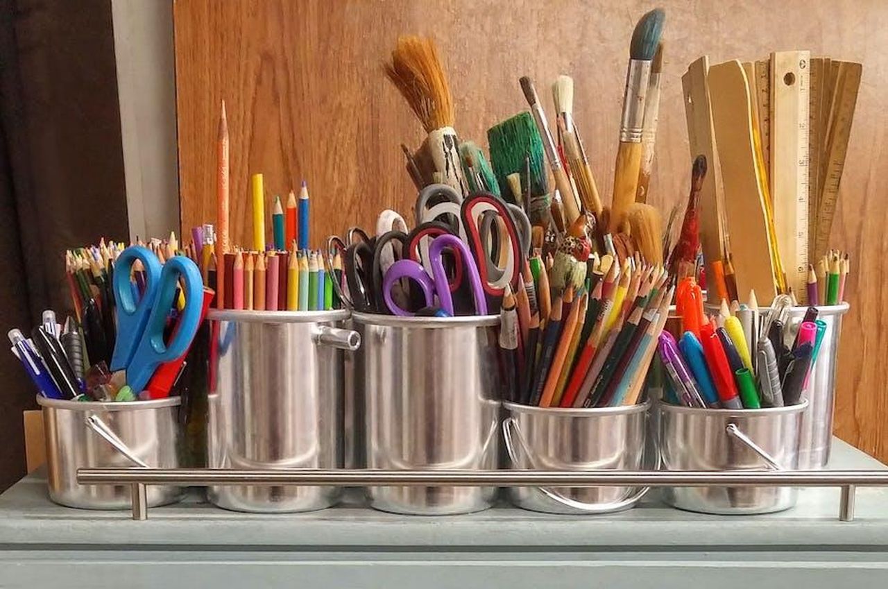 Come_utilizzare_i_Honeysticks_Petals_cWJgTb7IgN - Confidenze24 Source: Pixabay - pexels - A diverse collection of art supplies in metallic buckets on a wooden table.