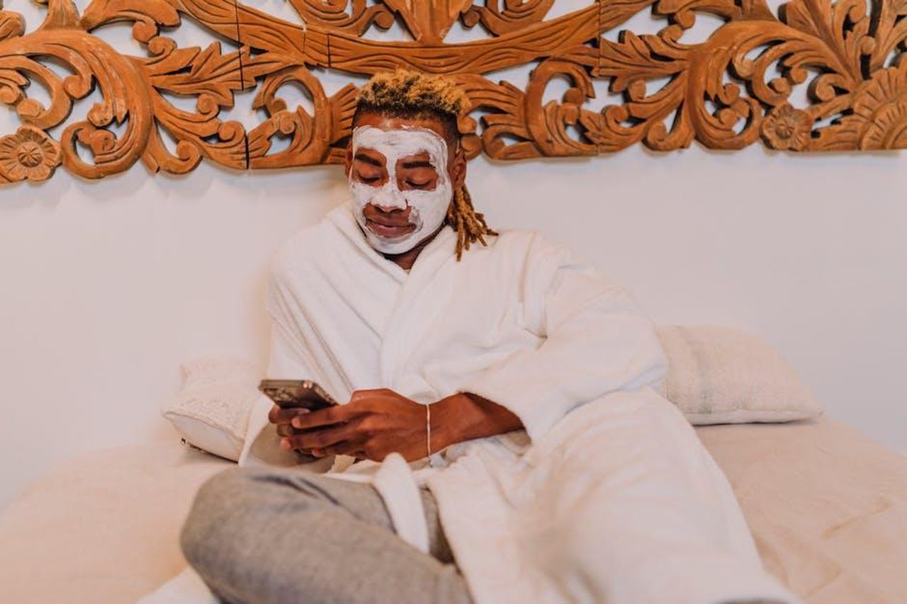 Come_utilizzare_il_prodotto_e1ayvIjvxk - Confidenze24 Source: RDNE Stock project - pexels - A man enjoys a relaxing spa day at home, applying a facemask while using his smartphone.