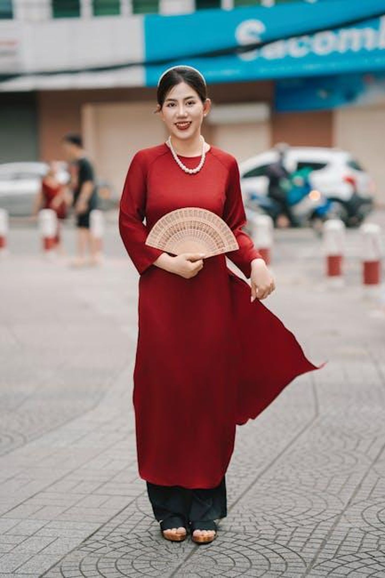 Commenti_dei_fan_sulla_riunione_LKX8bNzG4X - Confidenze24 Source: nguyen kha - pexels - Elegant woman in red dress with fan posing outdoors on street.