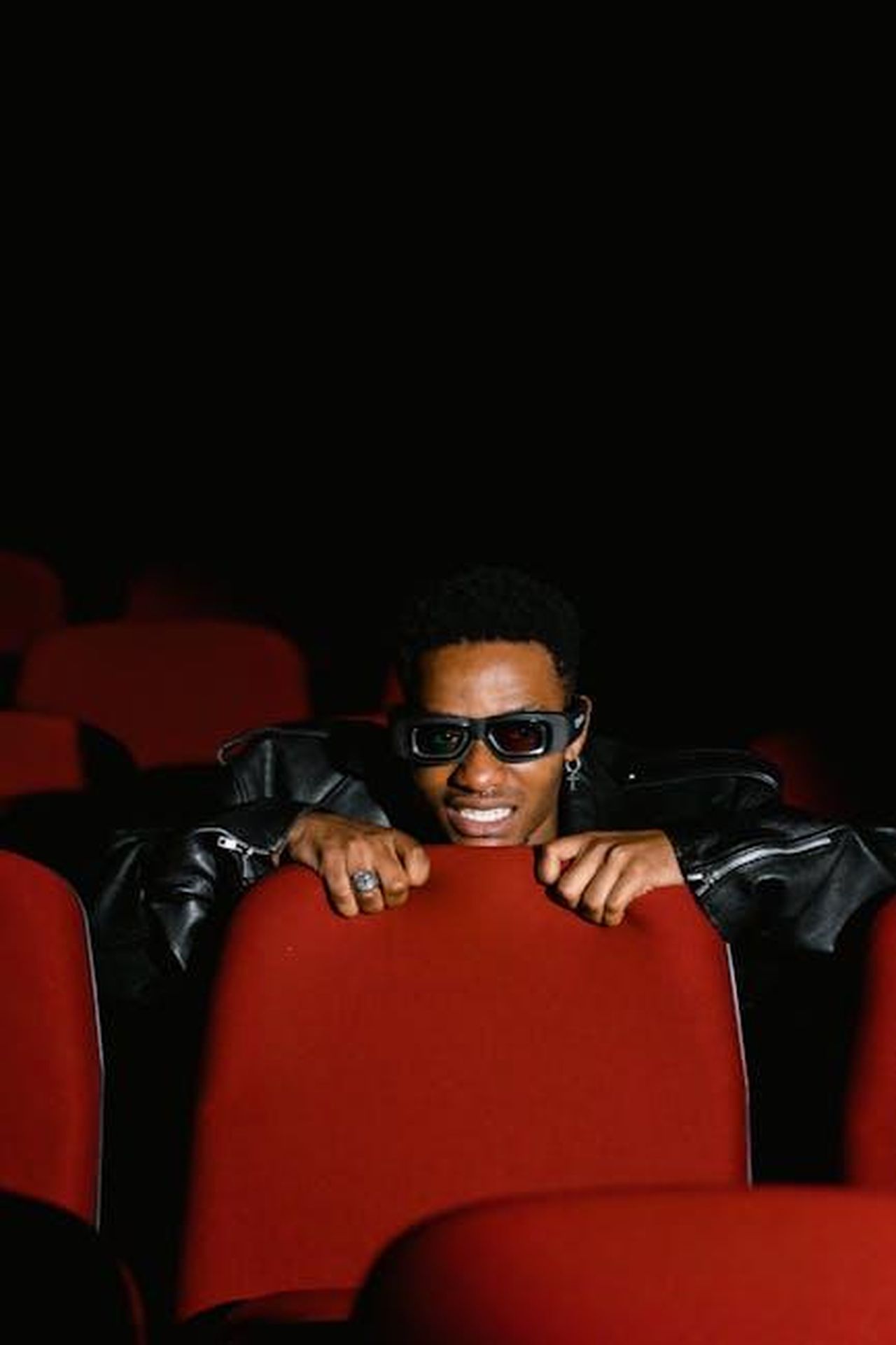 Commenti_dei_telespettatori_sulloutfit_di_Cat_2uTZHH0dEH - Confidenze24 Source: Tima Miroshnichenko - pexels - A man in 3D glasses sits in a dark cinema, grasping the red chair.