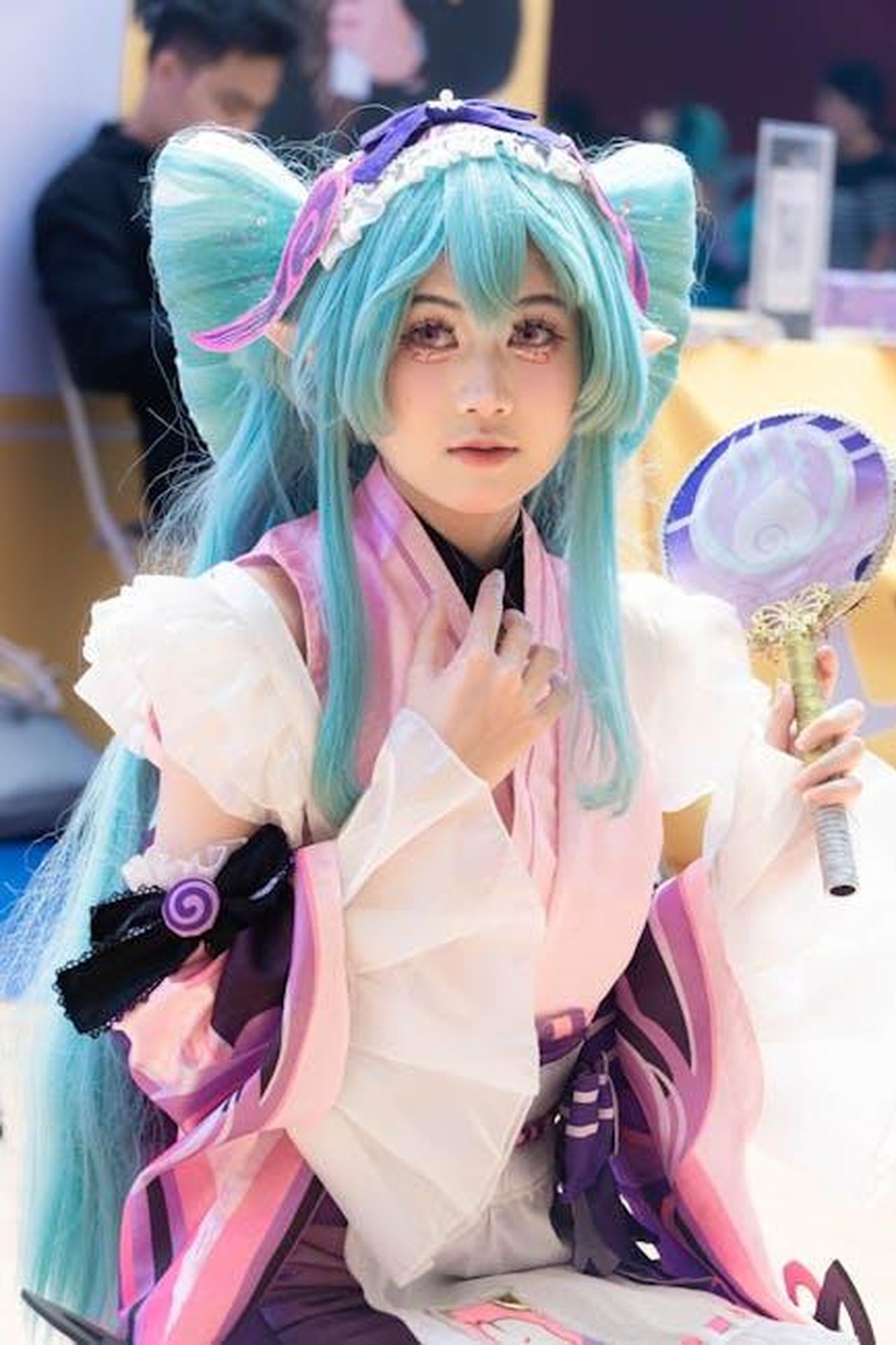 Commenti_entusiasti_dei_fan_sui_teaser_kXB2YbG3Ge - Confidenze24 Source: Hoàng Tiến Anh - pexels - Vibrant portrayal of a cosplayer in colorful costume with blue hair and fan at an event.