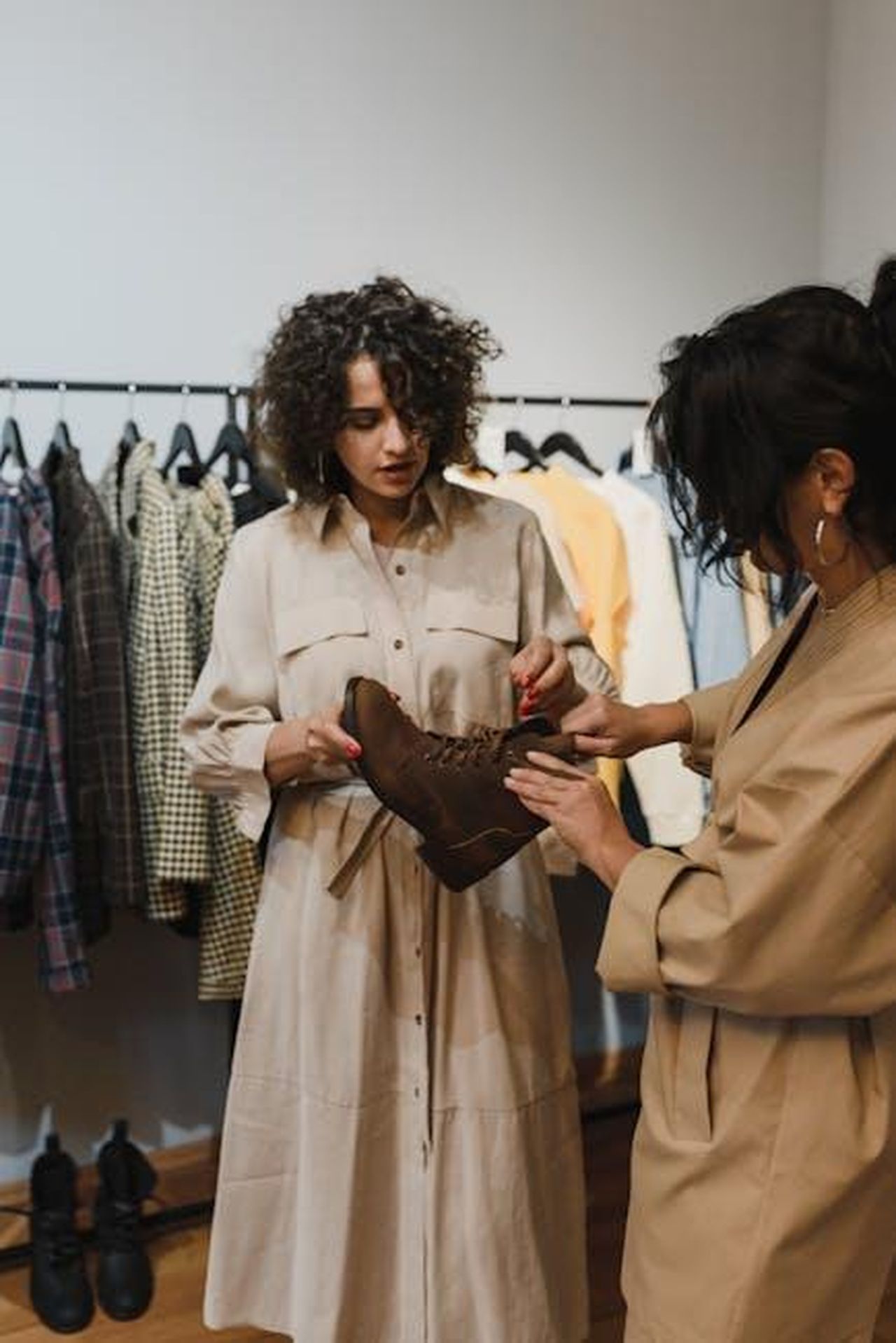 Consigli_per_lacquisto_vL8h1AtsId - Confidenze24 Source: Arina Krasnikova - pexels - Two women shopping for stylish brown boots in a fashionable clothing boutique.