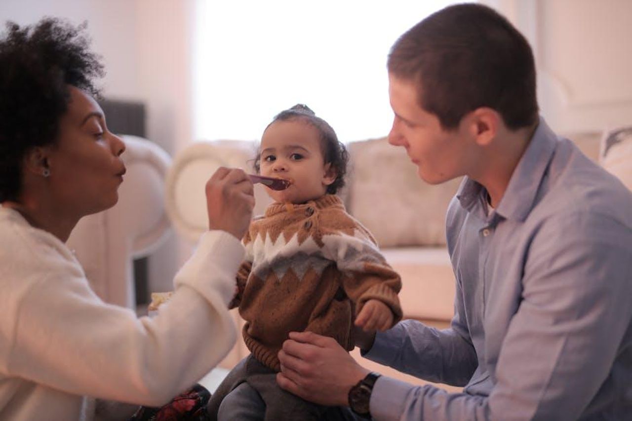 Coparenting_con_Zayn_Malik_k22rfeG5lq - Confidenze24 Source: Andrea Piacquadio - pexels - A nurturing indoor scene of parents feeding their baby, capturing love and togetherness.
