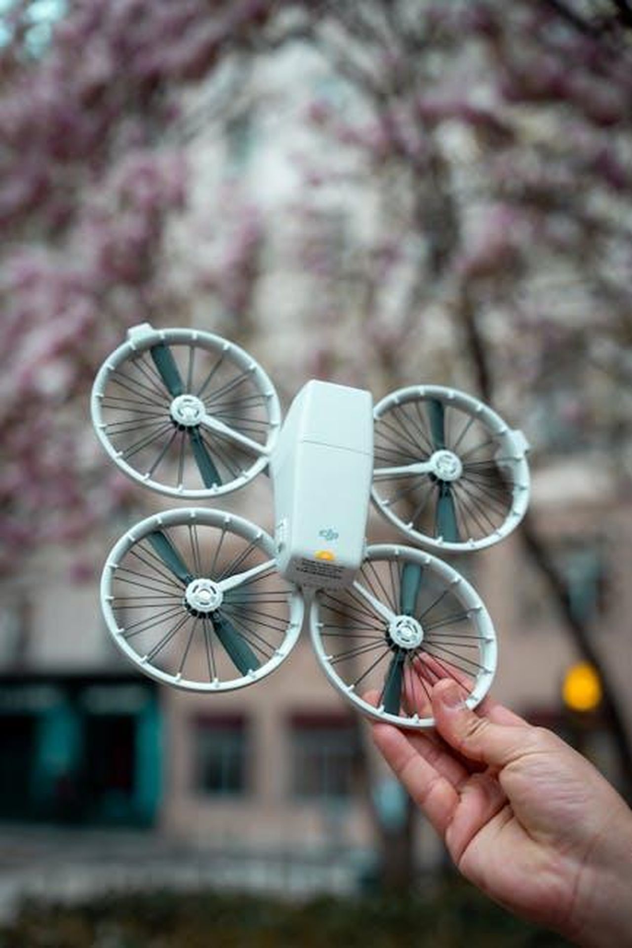 Cosa_Succeder_Dopo_G3sitcNkX2 - Confidenze24 Source: Assedrani Official - pexels - Close-up of a drone held in hand against spring blossoms. Vibrant and modern.