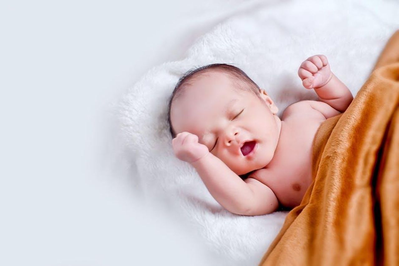 Cosa__successo_al_bambino_lasciato_sulla_soglia_di_Dolly_Parton_MwsA06DptZ - Confidenze24 Source: kelvin agustinus - pexels - A peaceful sleeping infant wrapped in a soft, warm blanket on a cozy white surface.
