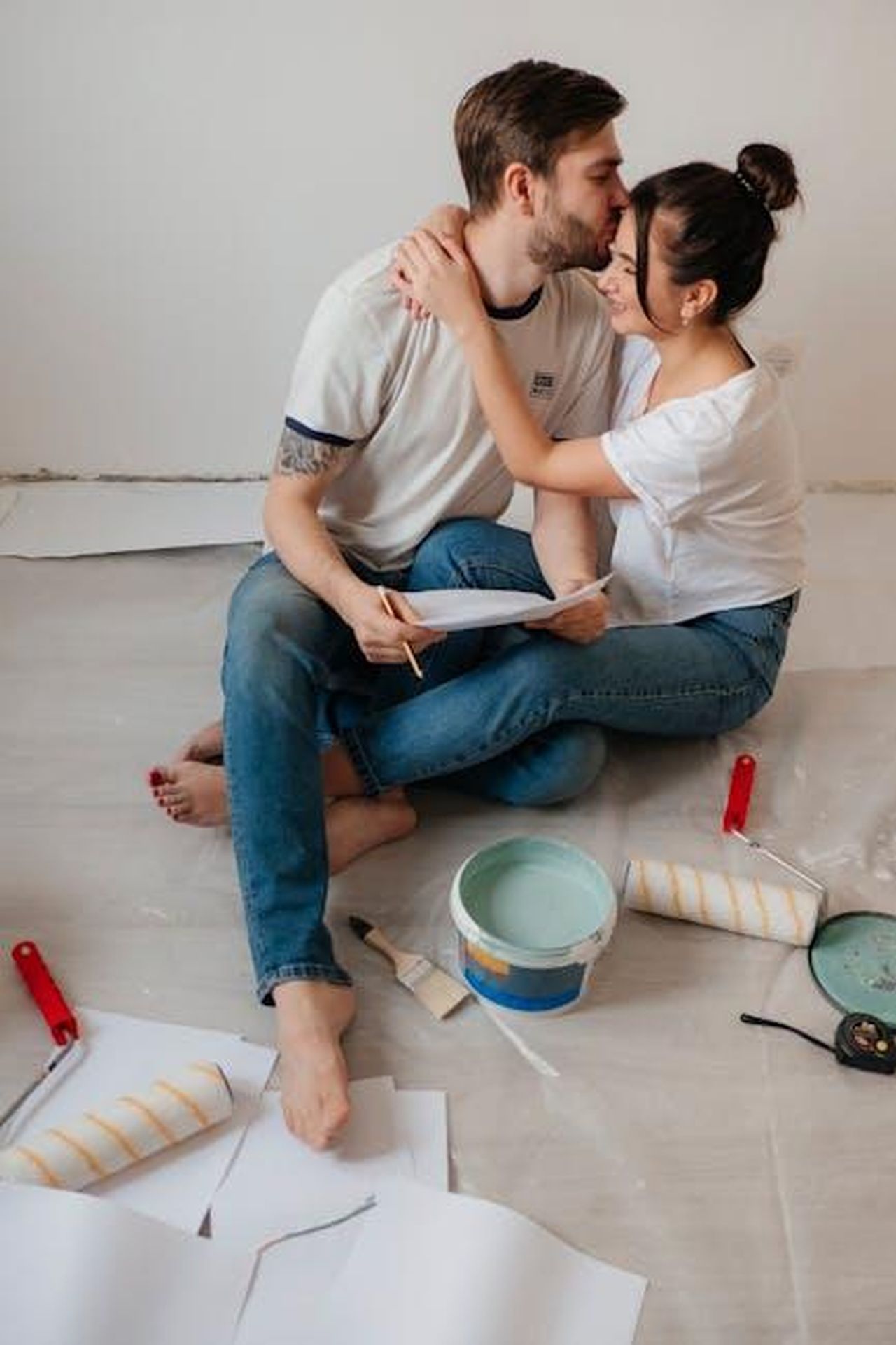 Cosa_fare_se_ho_gi_registrato_mio_figlio_e_lho_turbato_MX4uIseDNm - Confidenze24 Source: Maria Ovchinnikova - pexels - A loving couple embracing on the floor while renovating their apartment with paint rollers and brushes.