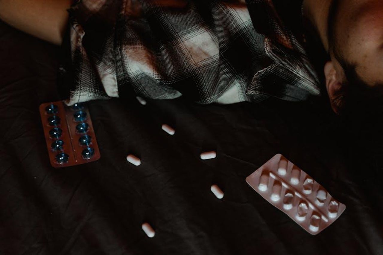 Cosa_ha_detto_Ant_McPartlin_sulla_sua_dipendenza_KCs12t84GI - Confidenze24 Source: MART PRODUCTION - pexels - Dark scene with pills scattered near a person, suggesting themes of mental health and medication.