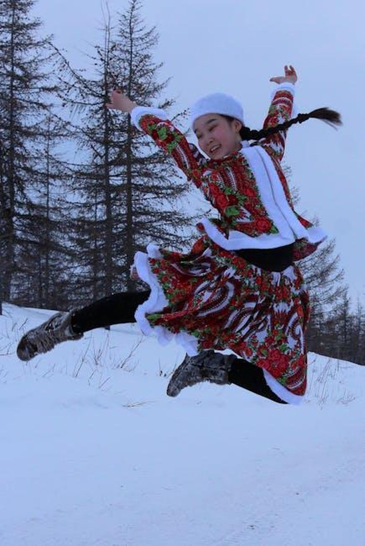 Cosa_ha_detto_Dan_riguardo_alla_sua_eliminazione_xjlQwVjt9d - Confidenze24 Source: Александр Велигура - pexels - A woman joyfully leaps in snow wearing colorful traditional attire against a winter landscape.