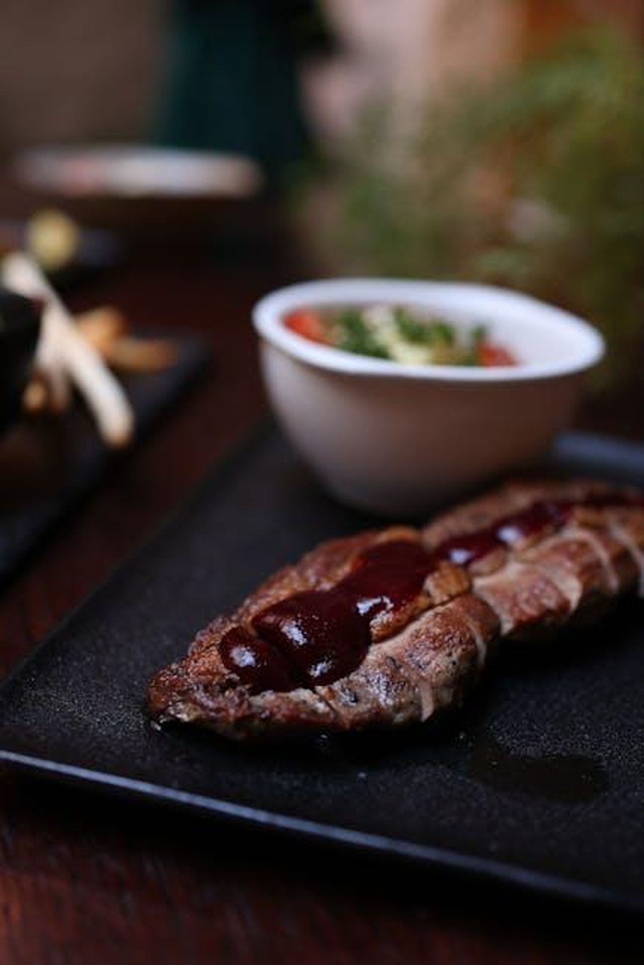 Cosa_ha_detto_KSI_su_Roman_Kemp_18tw0SEXrZ - Confidenze24 Source: Valeria Boltneva - pexels - Juicy steak with sauce served with a fresh side salad on a dark plate.