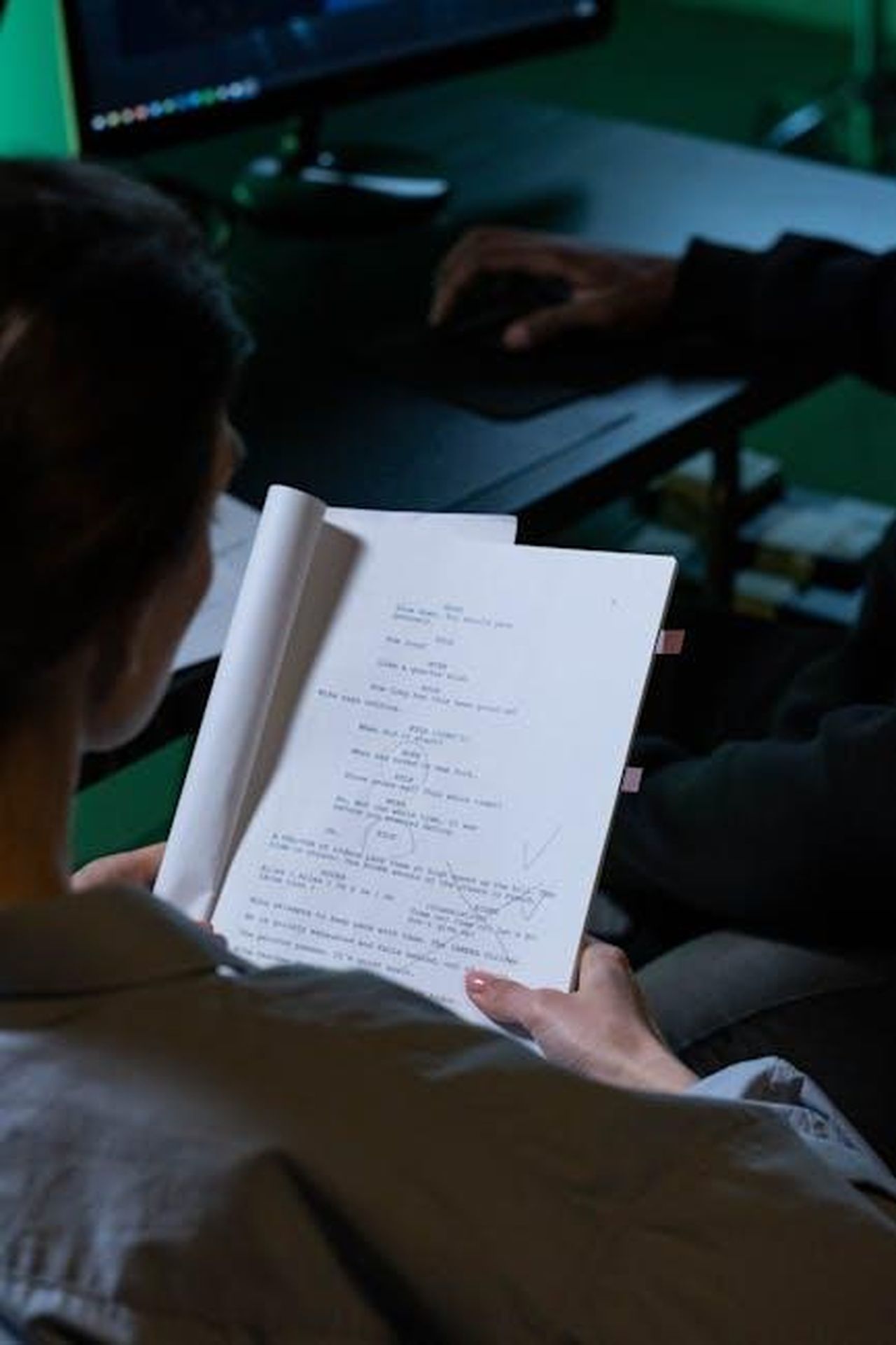 Cosa_ha_fatto_Alice_Haig_prima_di_EastEnders_xuKXxARoNK - Confidenze24 Source: Ron Lach - pexels - Person reading a script with notes in a dimly lit workspace, viewed over the shoulder.