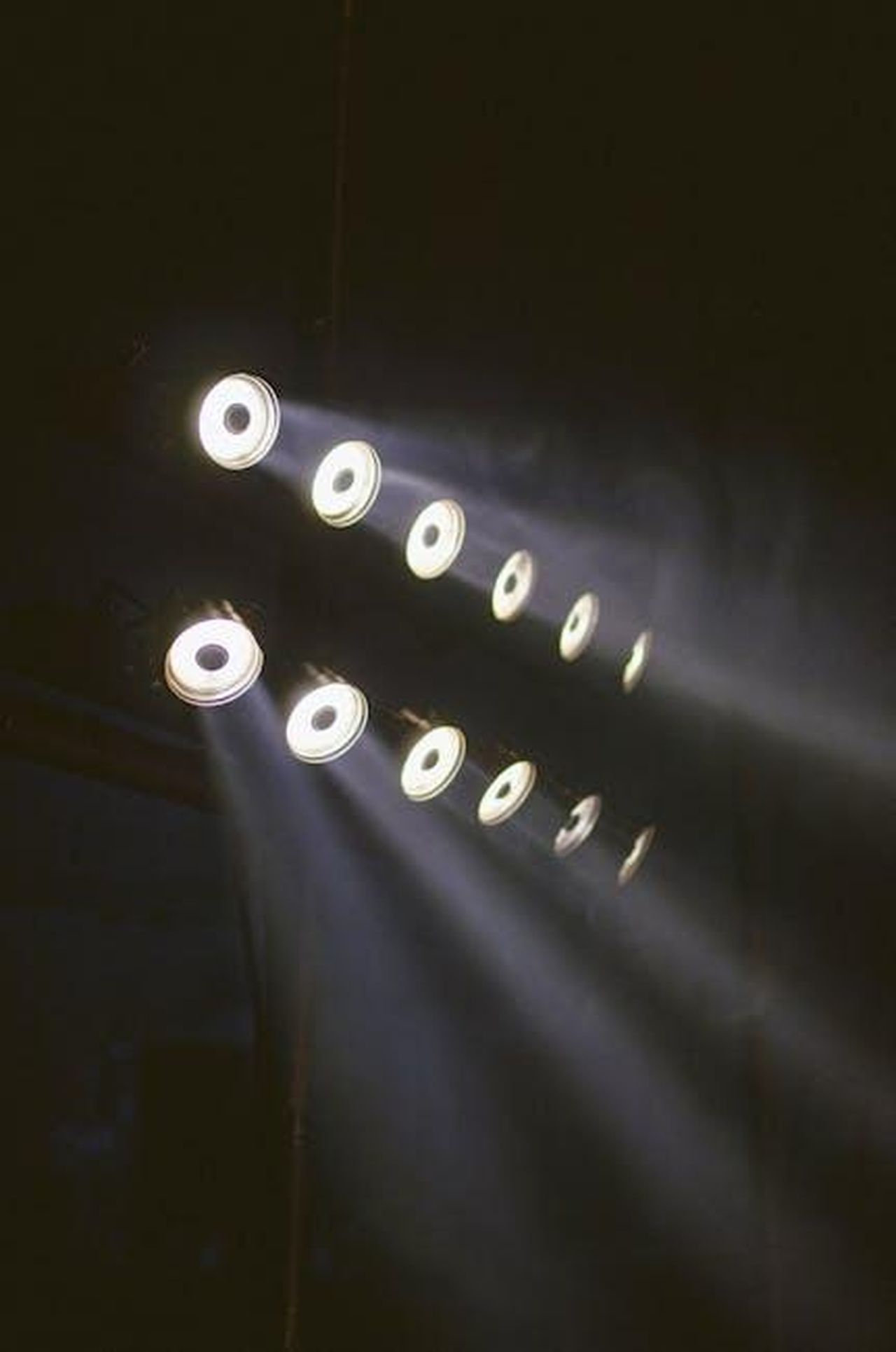 Cosa_hanno_affermato_le_fonti_oxFxYUVfSO - Confidenze24 Source: Isabella Mendes - pexels - Array of LED lights casting beams in a dark, moody industrial space.