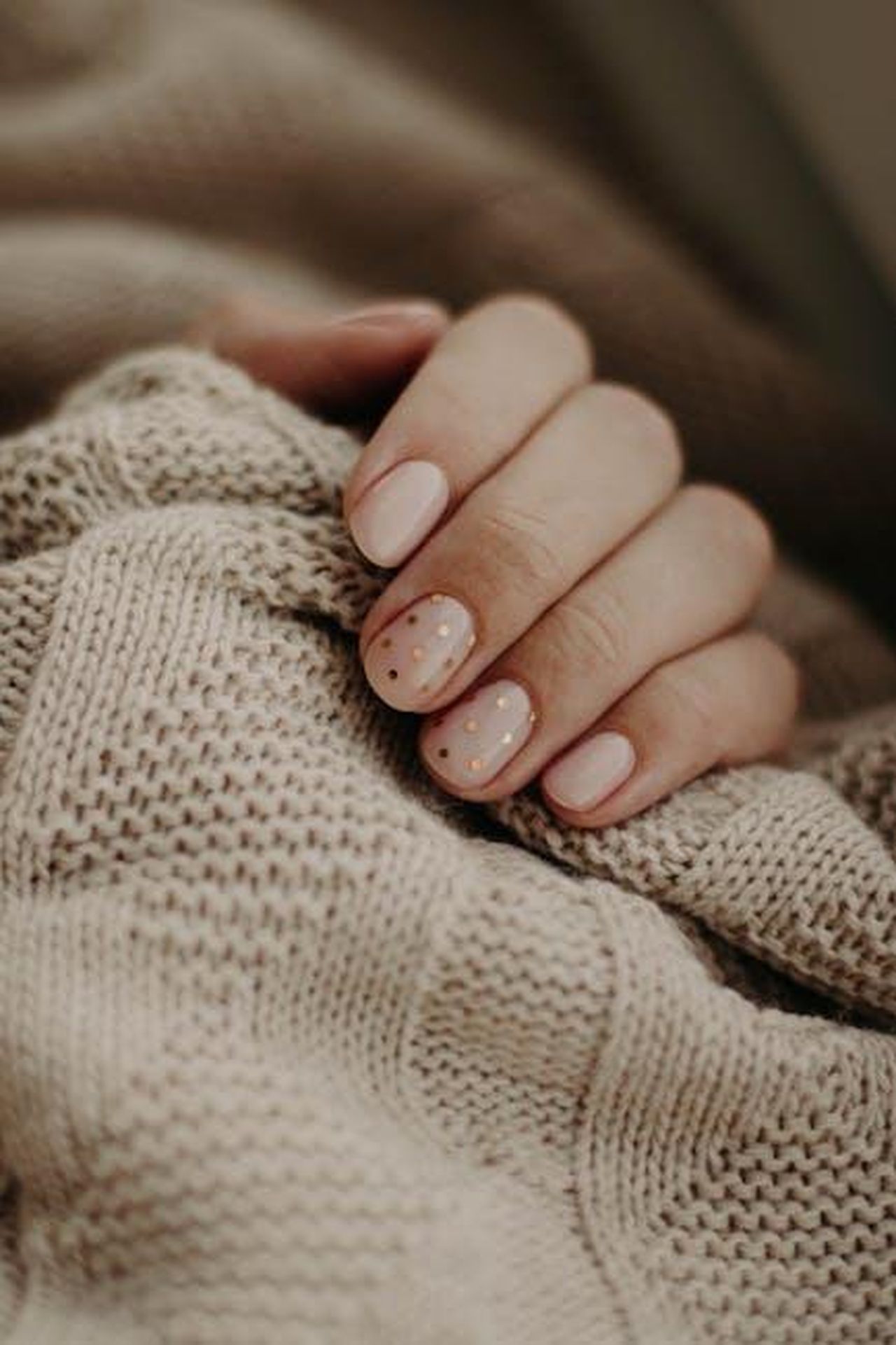Cosa_ne_pensano_gli_acquirenti_HKcZLnOZFQ - Confidenze24 Source: Kristina Paukshtite - pexels - Close-up of a hand with polka dot manicured nails wrapped in a knitted sweater.